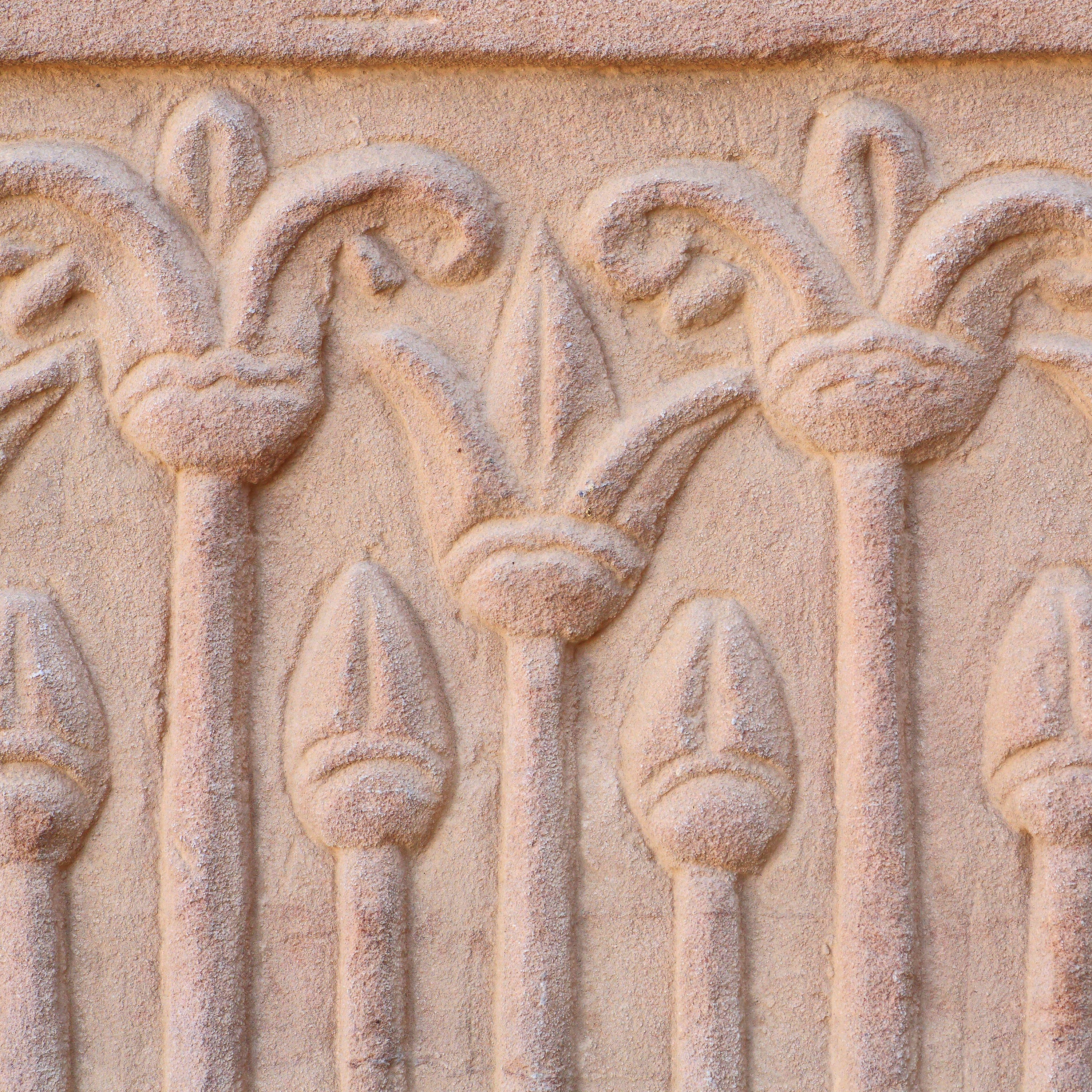 Ancient Egyptian lotus flower stone carving with repeating floral motif.