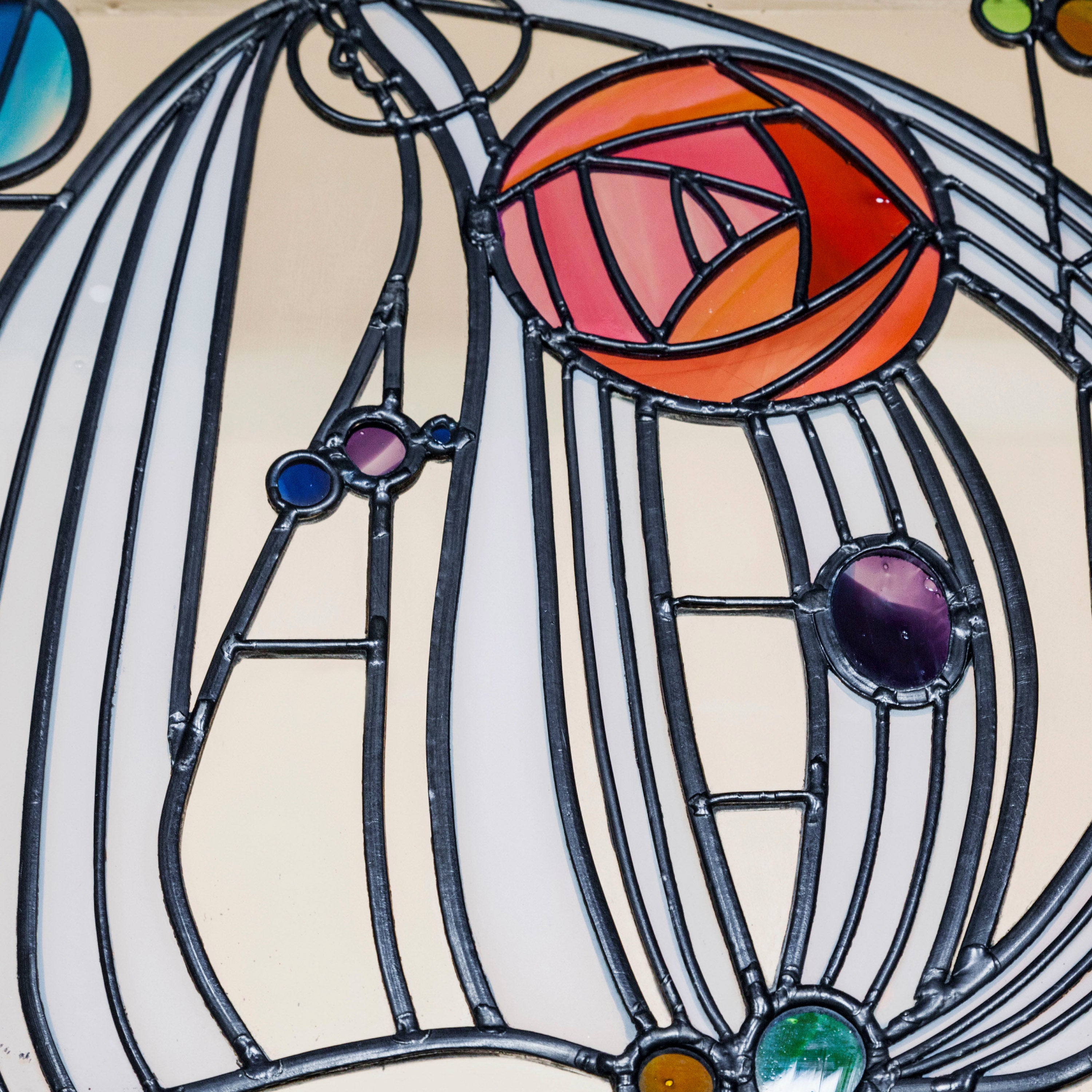 Charles Rennie Mackintosh inspired stained glass with rose motif and geometric lines.