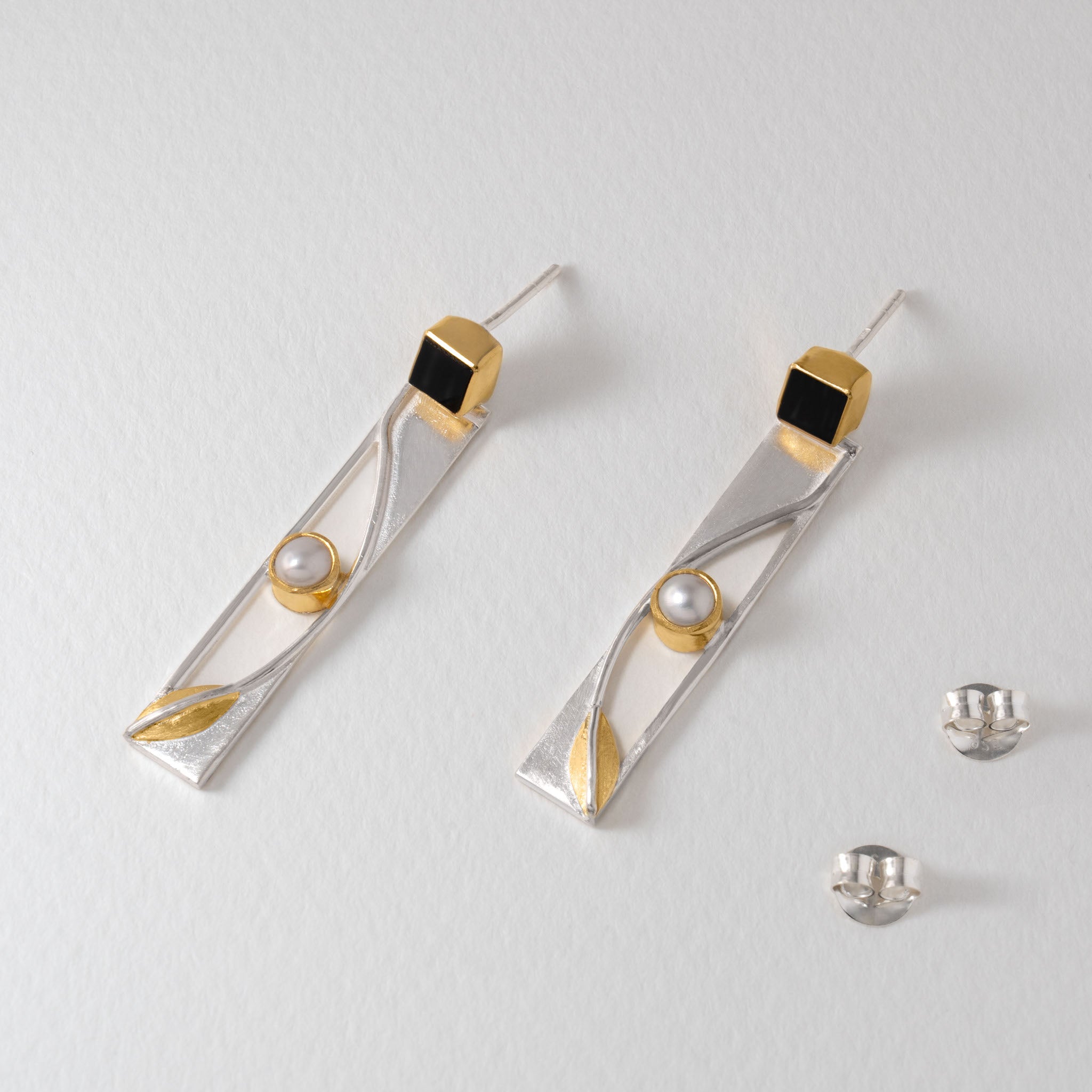 Elegant Art Deco drop earrings with geometric silver design, pearl centre and bold onyx stone.