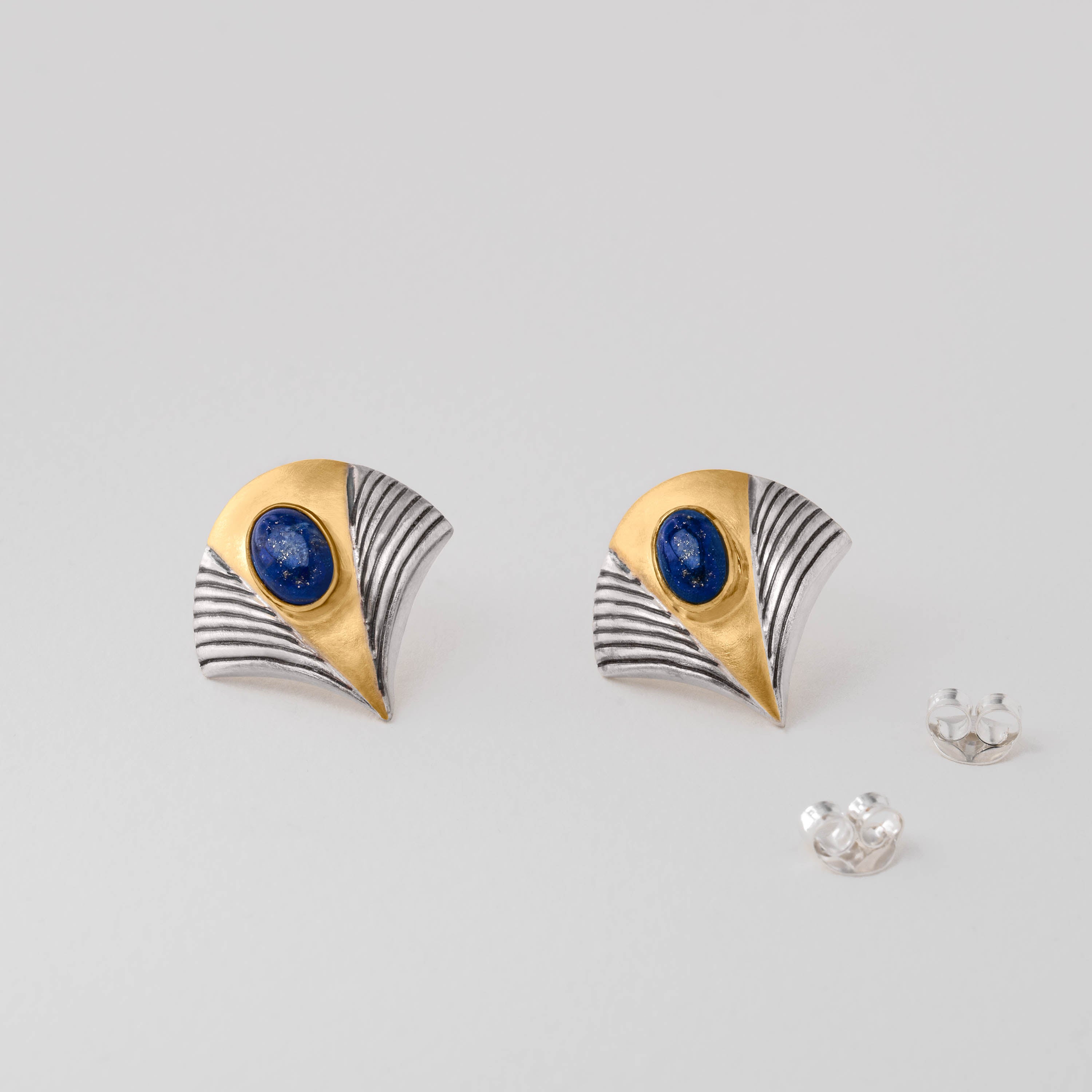 Tutankhamun-inspired stud earrings in sterling silver with 18ct gold plate and deep blue lapis lazuli. Jewellery echoing the pharaoh’s golden mask with lapis inlay, bringing ancient Egyptian history and grandeur into a modern design.
