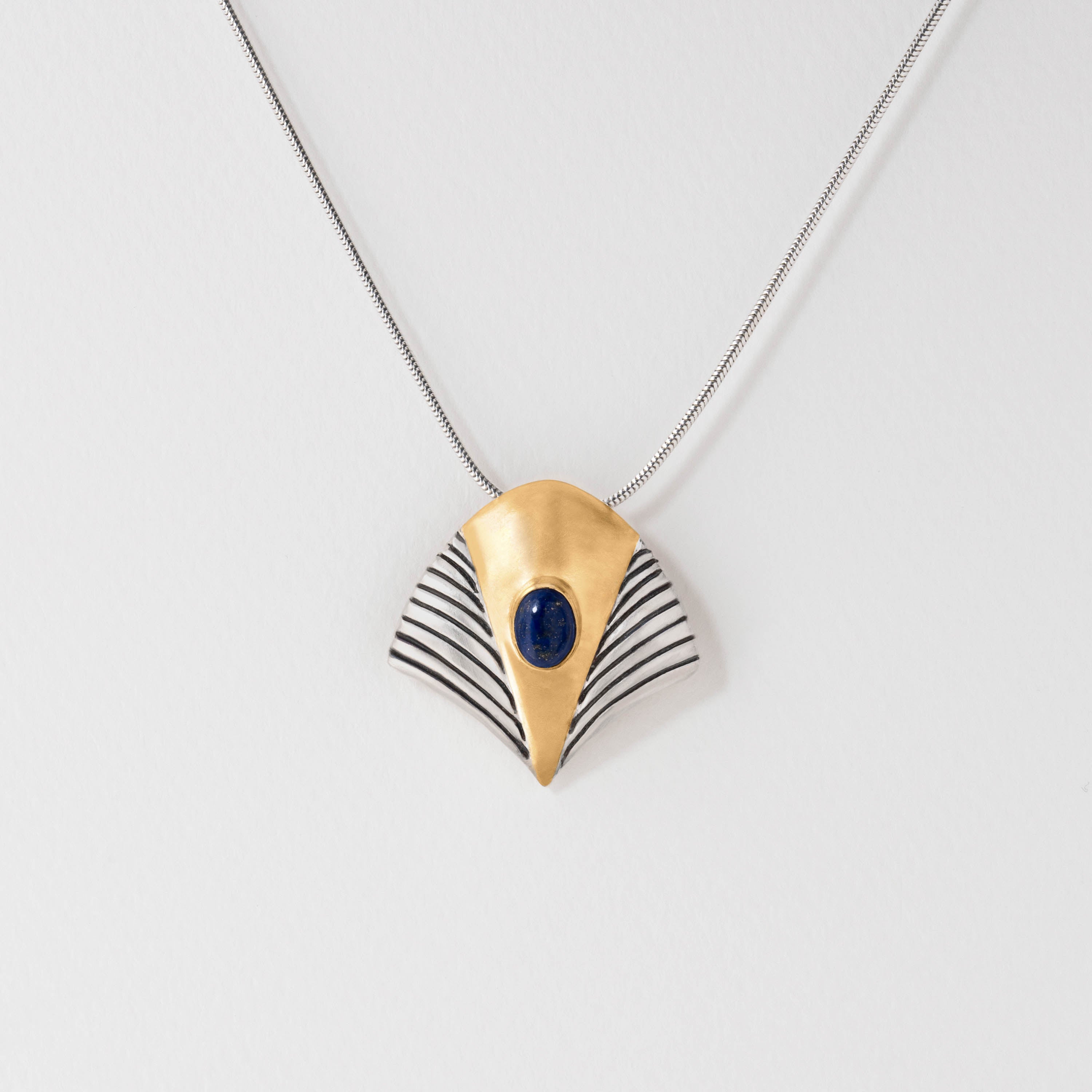 A gold-colored pendant necklace featuring a Lapis Lazuli striped design, displayed against a white background.