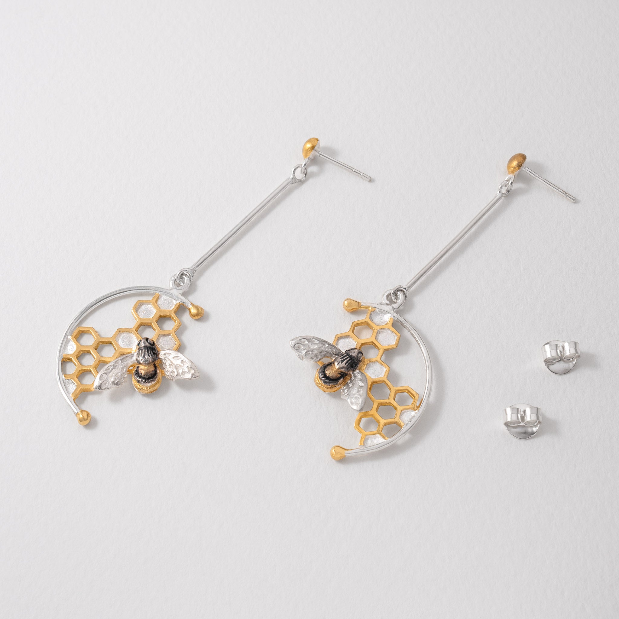 Nature inspired honeybee earrings in silver with gold detail and honeycomb design.