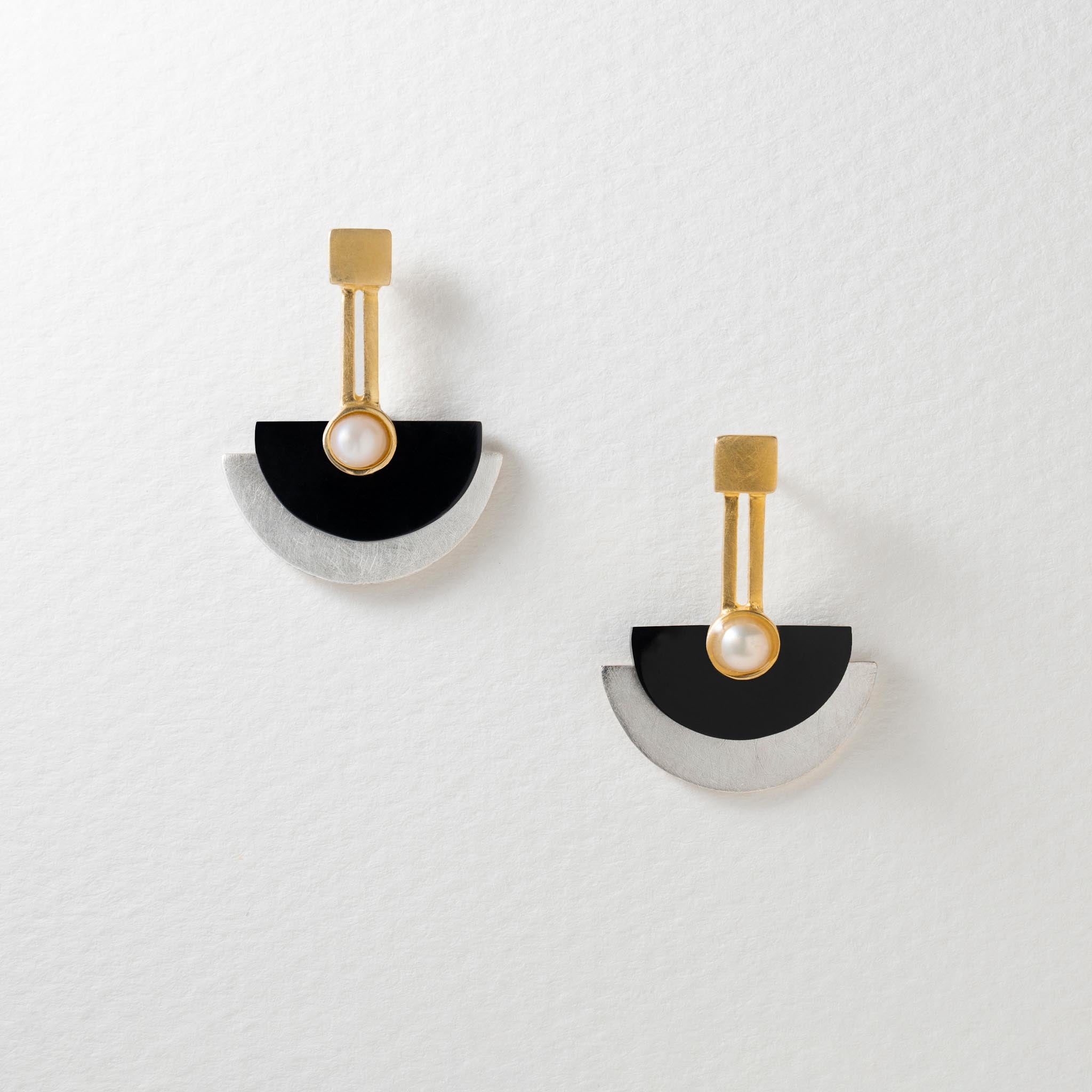 A pair of Art Deco style stud earrings with gold-plated accents, black resin, and shimmering pearls