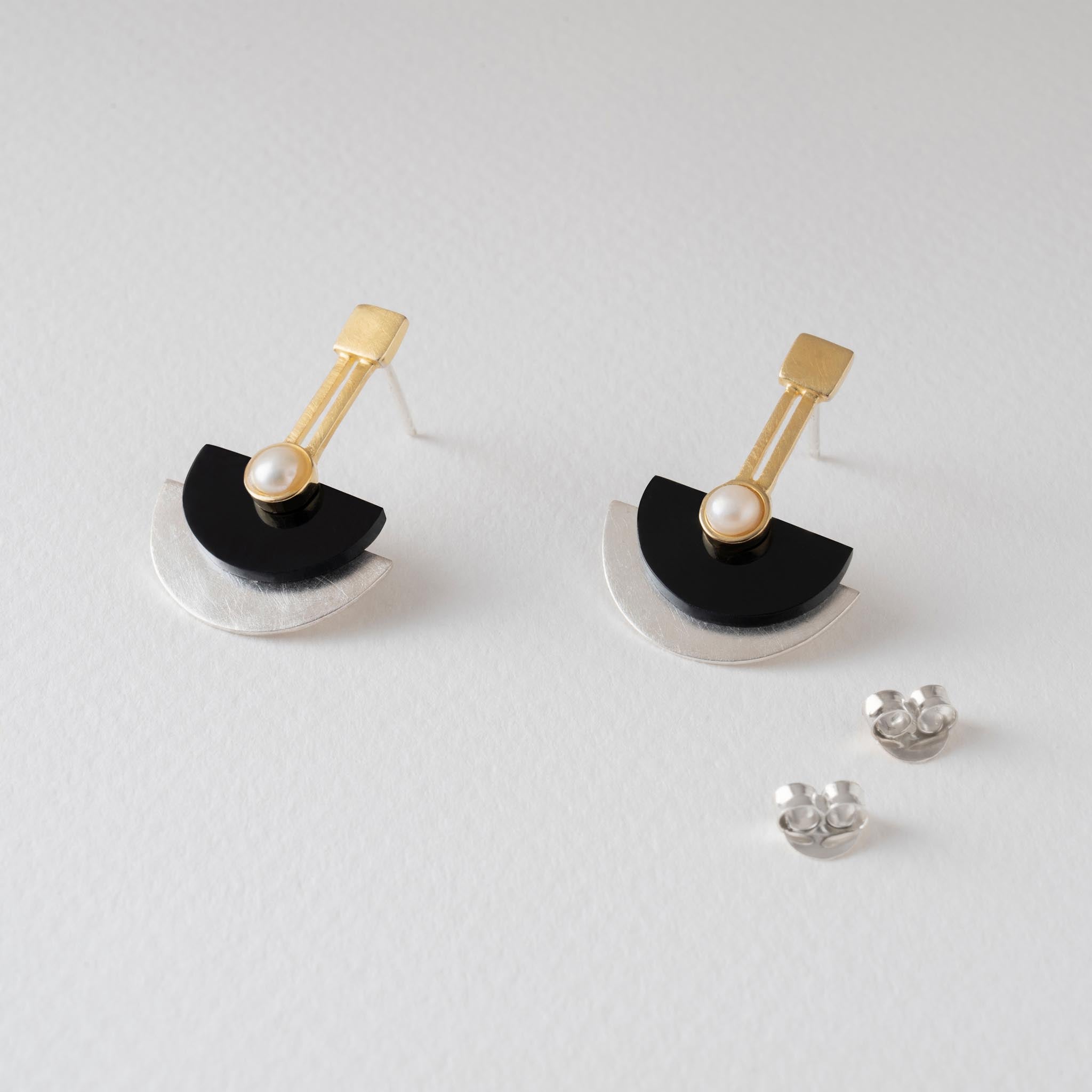 pair of statement art deco earrings with gold geometric design, black resin and silver semi circles and natural pearl