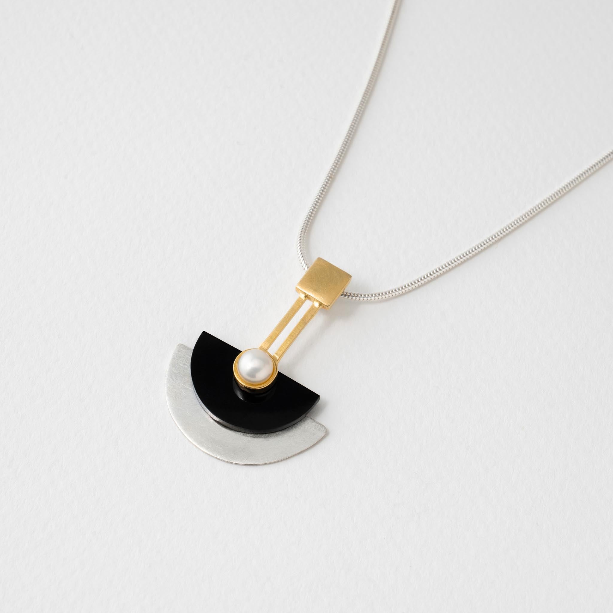 Art deco inspired pendant necklace with geometric semi circle design in sterling silver and black resin set with pearl