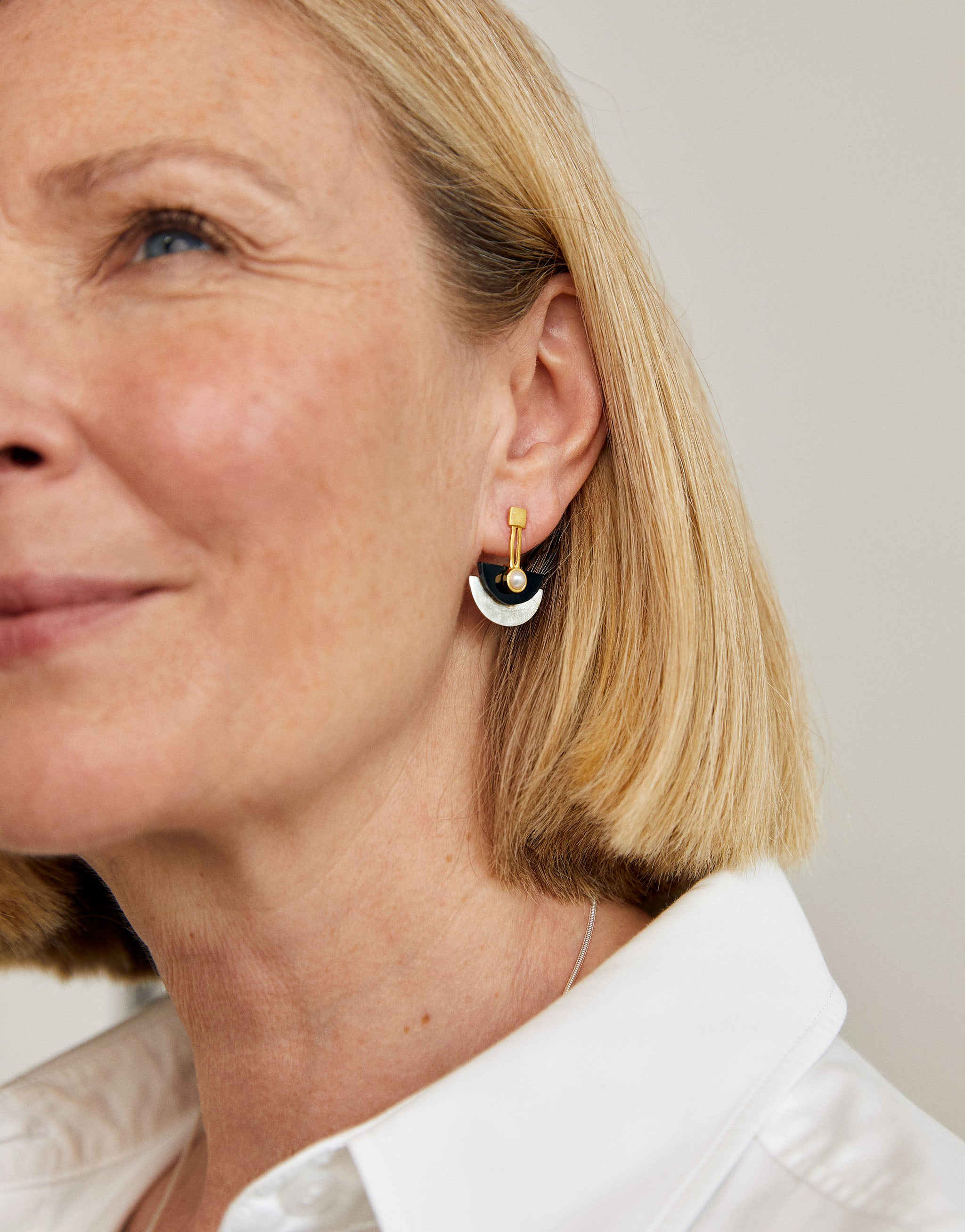 Art deco stud earrings with a gold bar and semi-circles in black resin and silver with a natural pearl.