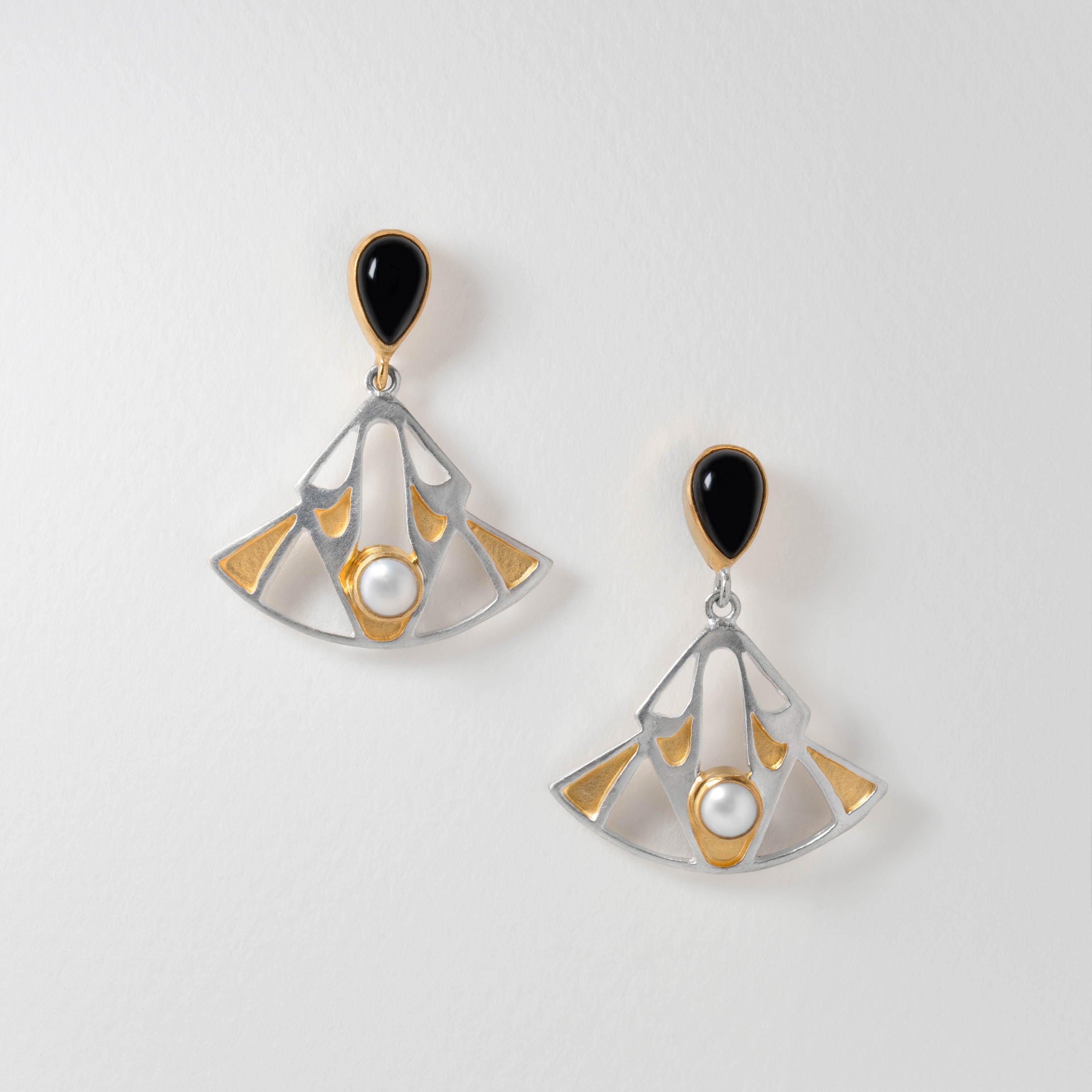 Art Deco inspired earrings in sterling silver with black onyx, pearl and gold-plated details. The bold geometric fan design reflects the glamour and elegance of the Jazz Age, bringing vintage sophistication to any look.