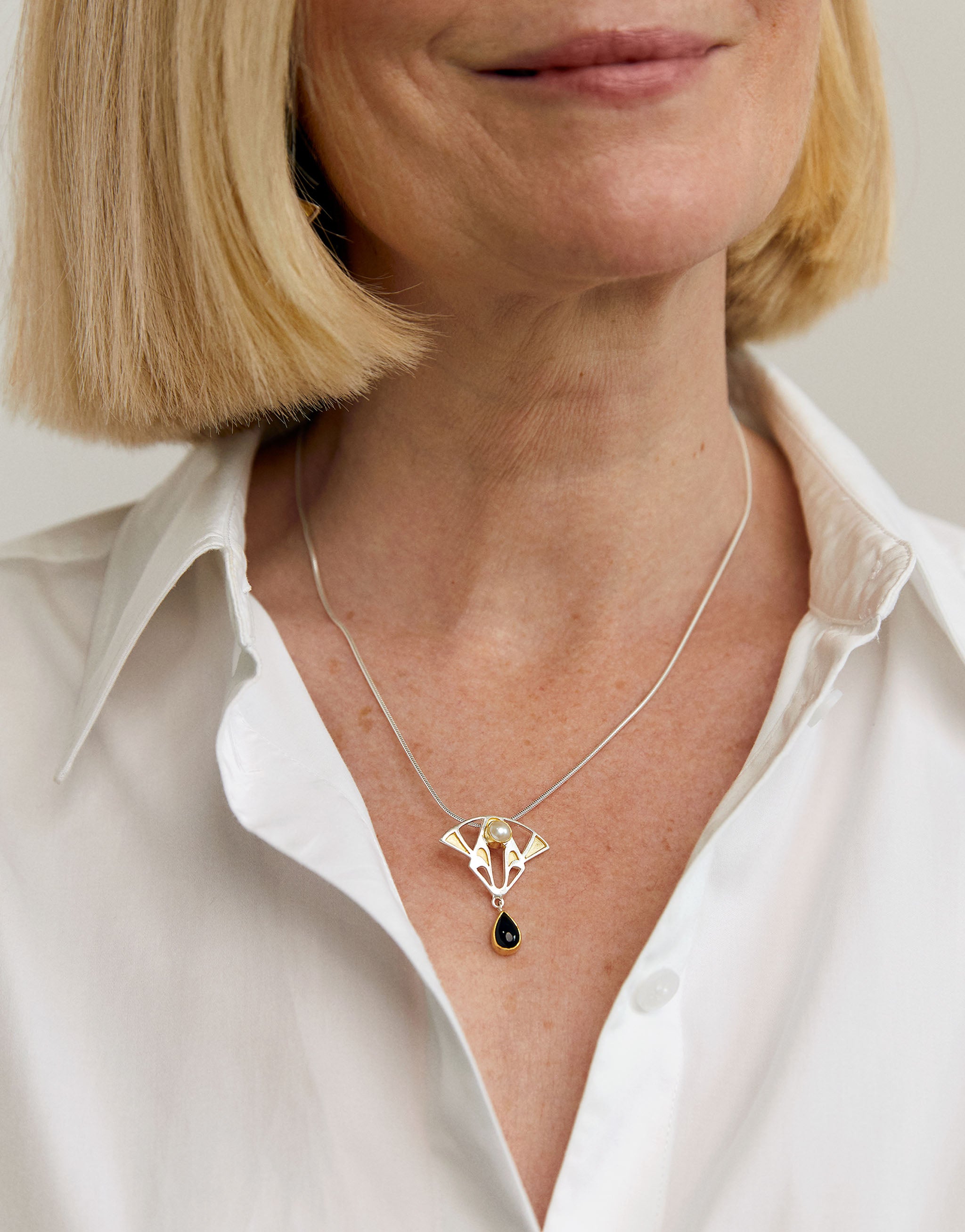 1930s inspired Art Deco pendant necklace in silver with gold accents, resin and pearl.