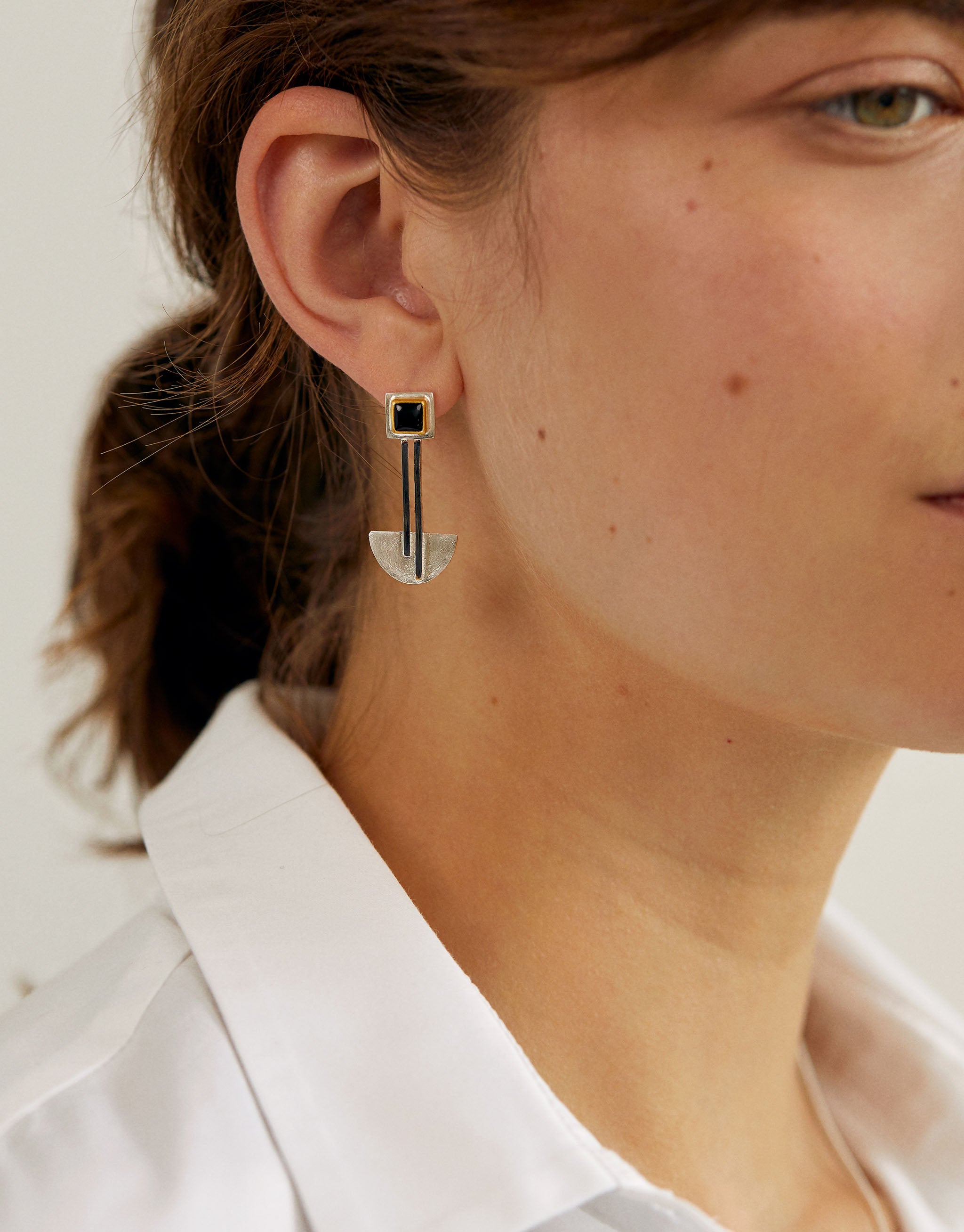 Bauhaus inspired earrings in sterling silver with 18ct gold plate and black onyx. Minimalist geometric drop design reflecting the Bauhaus ethos of balance, simplicity and modernist elegance.
