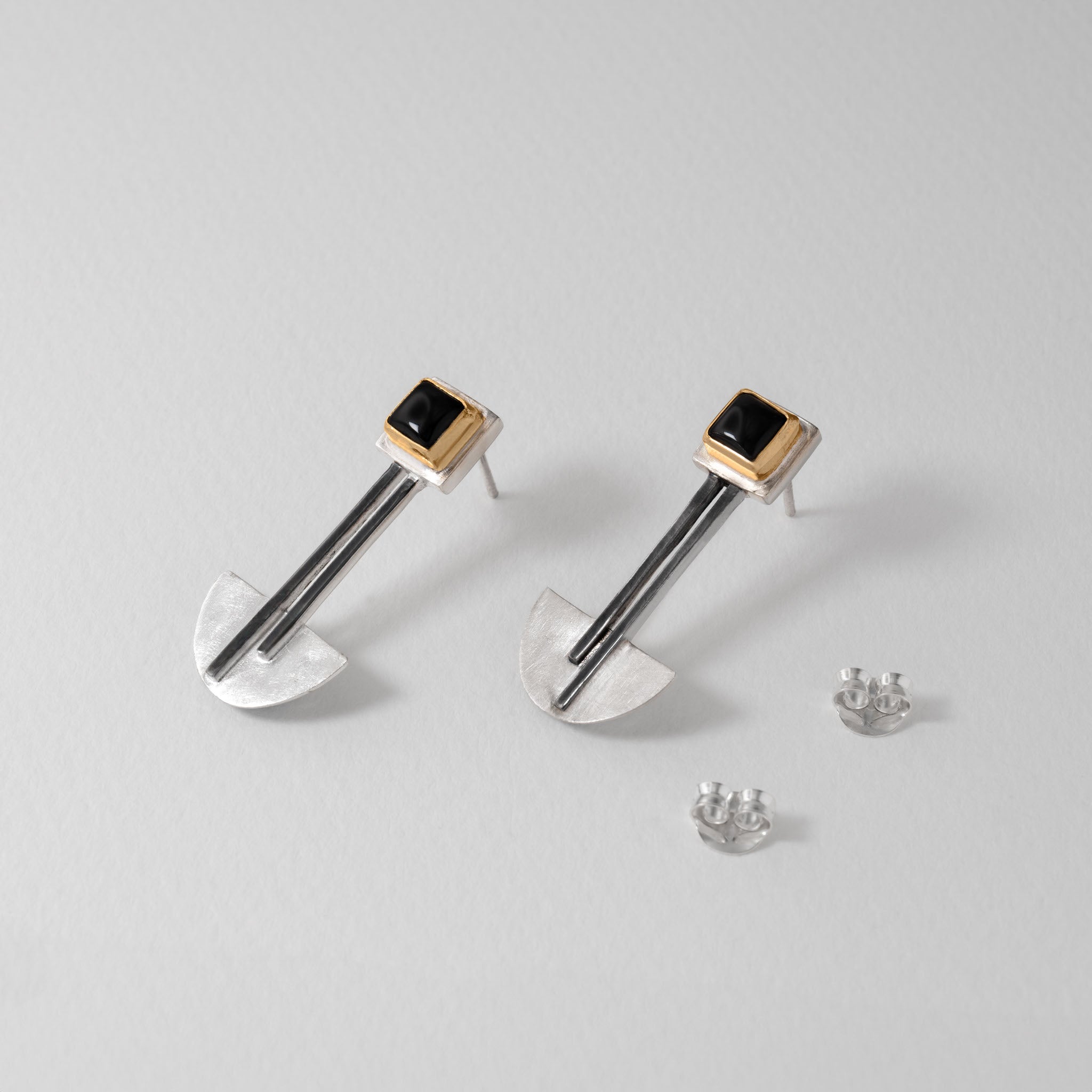 Sterling silver Bauhaus earrings featuring black onyx gemstones framed in 18ct gold plate. The modern geometric design combines clean lines with minimalist elegance, inspired by Bauhaus principles of form and function.