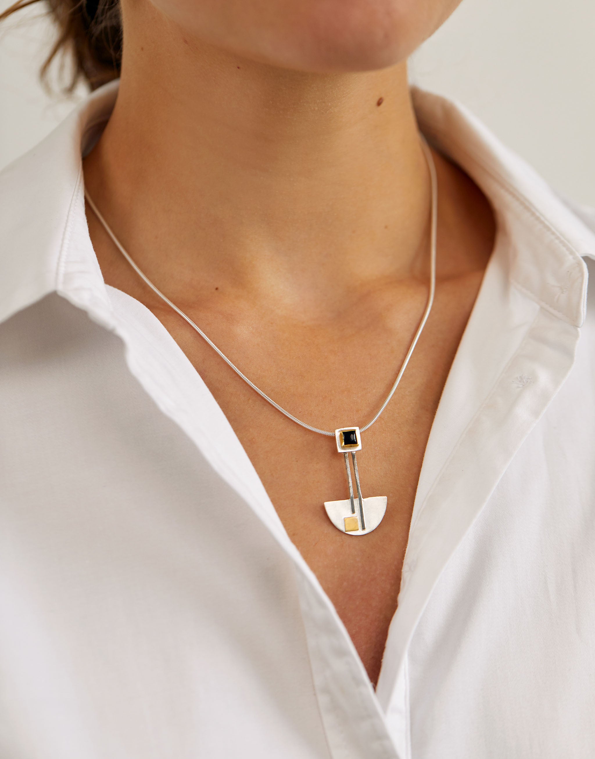 Bauhaus inspired sterling silver necklace with geometric pendant design, featuring a square black onyx stone and subtle 18ct gold plated accent. Minimalist necklace with clean, streamlined Bauhaus style.