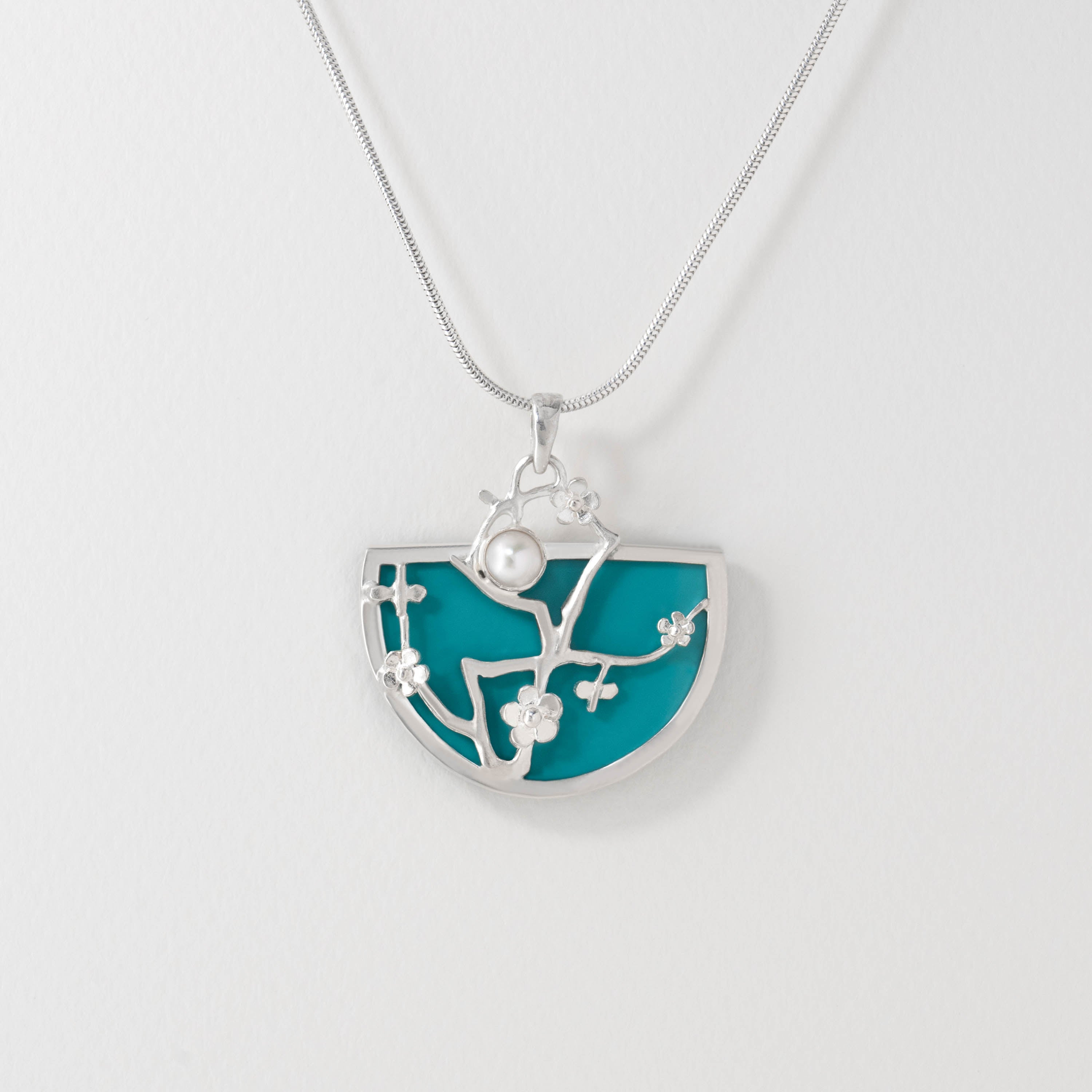 Van Gogh Almond Blossom inspired necklace in sterling silver with turquoise blue resin. The pendant features delicate silver blossom branches and a luminous central detail, echoing the beauty of Van Gogh’s iconic painting.