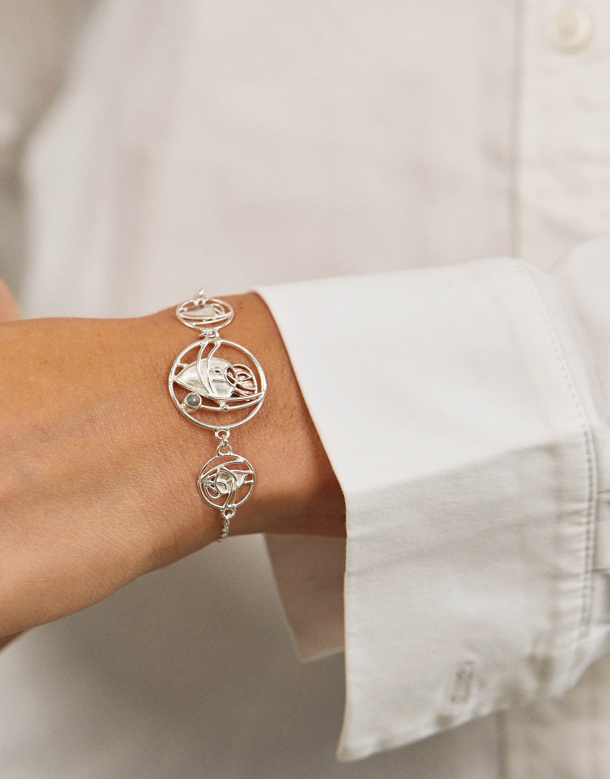 Charles Rennie Mackintosh inspired bracelet in sterling silver and copper with moonstone, featuring flowing Art Nouveau design echoing his stained-glass artistry.