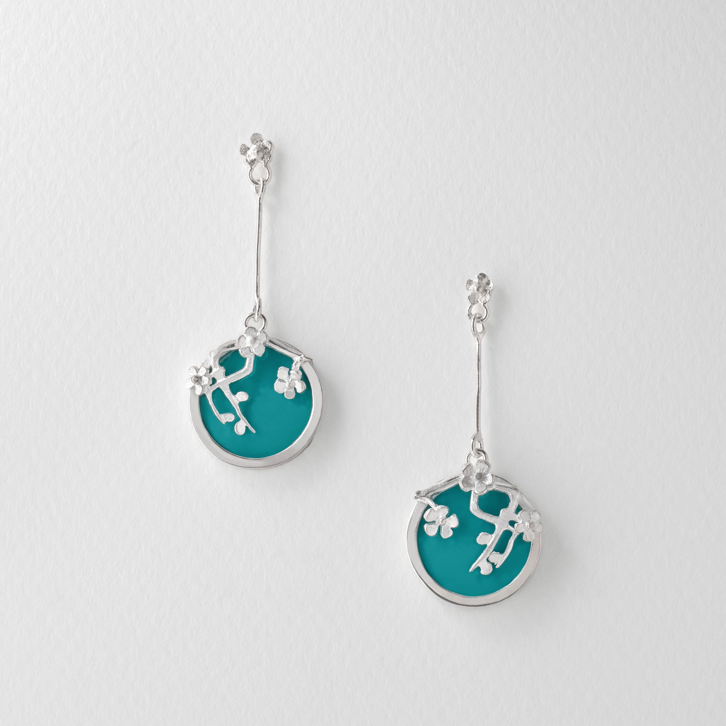 Van Gogh Almond Blossom inspired drop earrings in sterling silver with turquoise blue resin. The circular design features delicate silver blossom branches, echoing the artistry of Van Gogh’s famous painting.