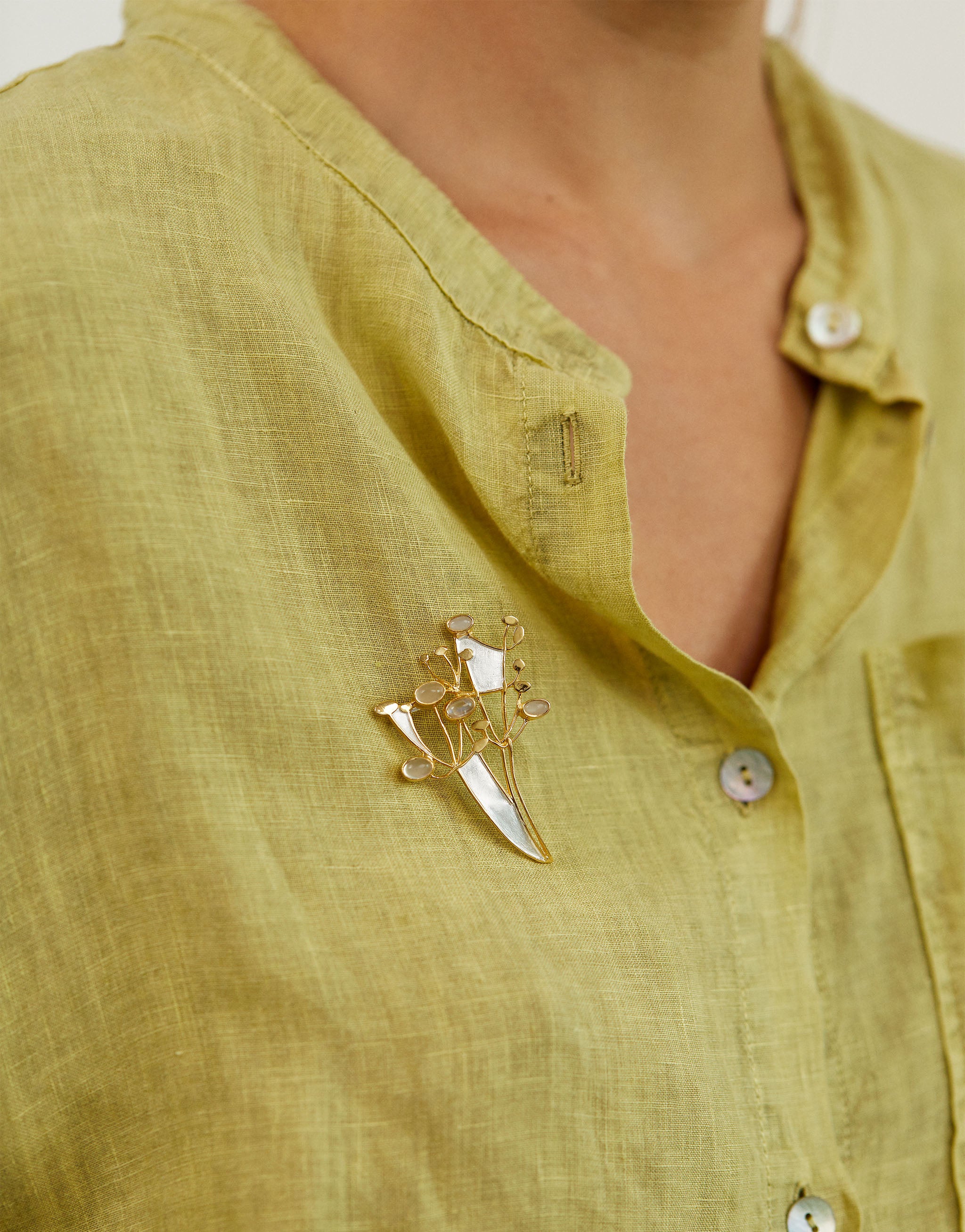 Elegant wildflower brooch in silver with gold-plated finish and moonstone stones.