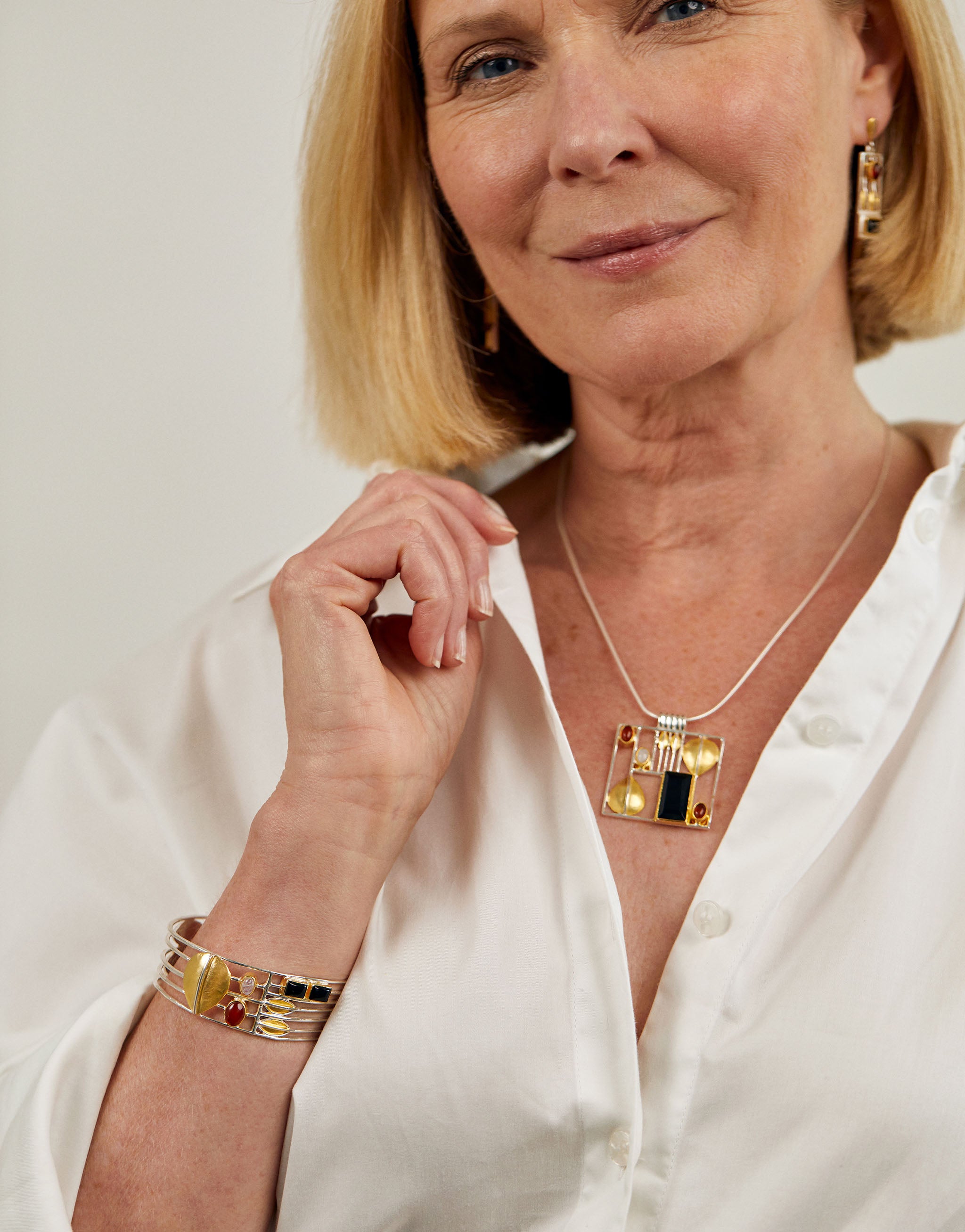 Josef Hoffmann style necklace with geometric silver pendant, amber and onyx gemstones.