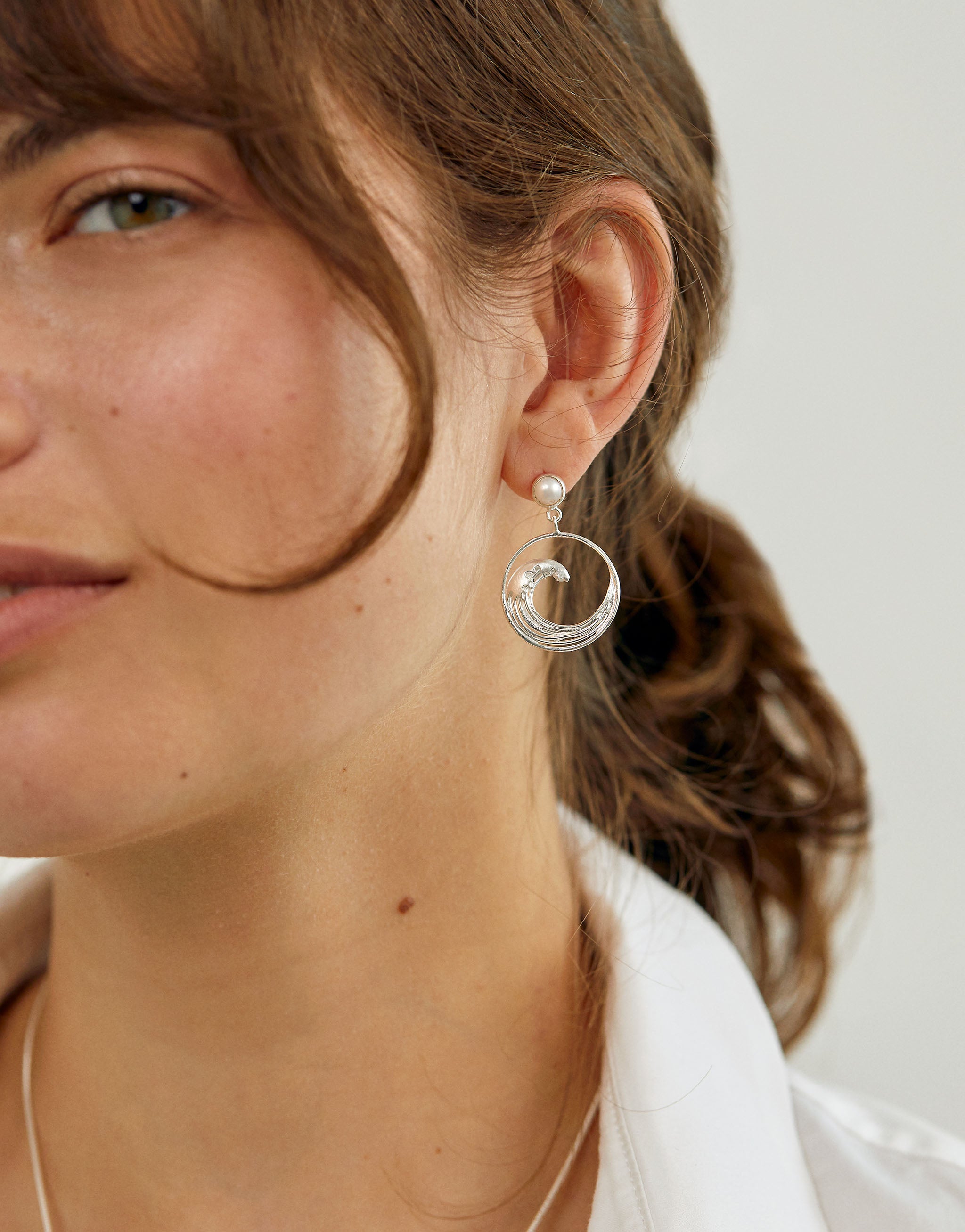 Sterling silver earrings with swirling wave motif inspired by Hokusai and adorned with pearl