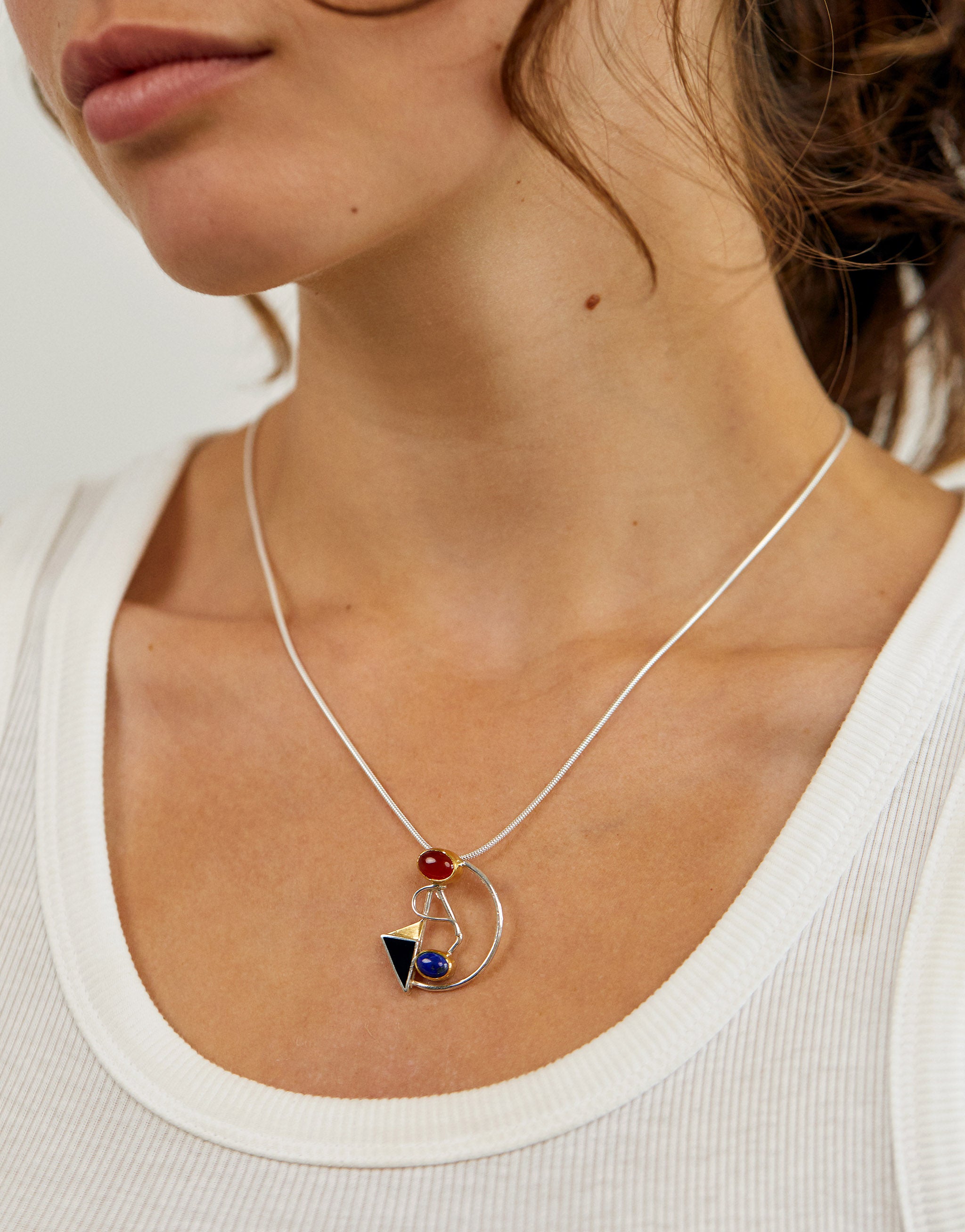 Kandinsky inspired pendant necklace in sterling silver with 18ct gold plate, lapis lazuli, onyx and carnelian.