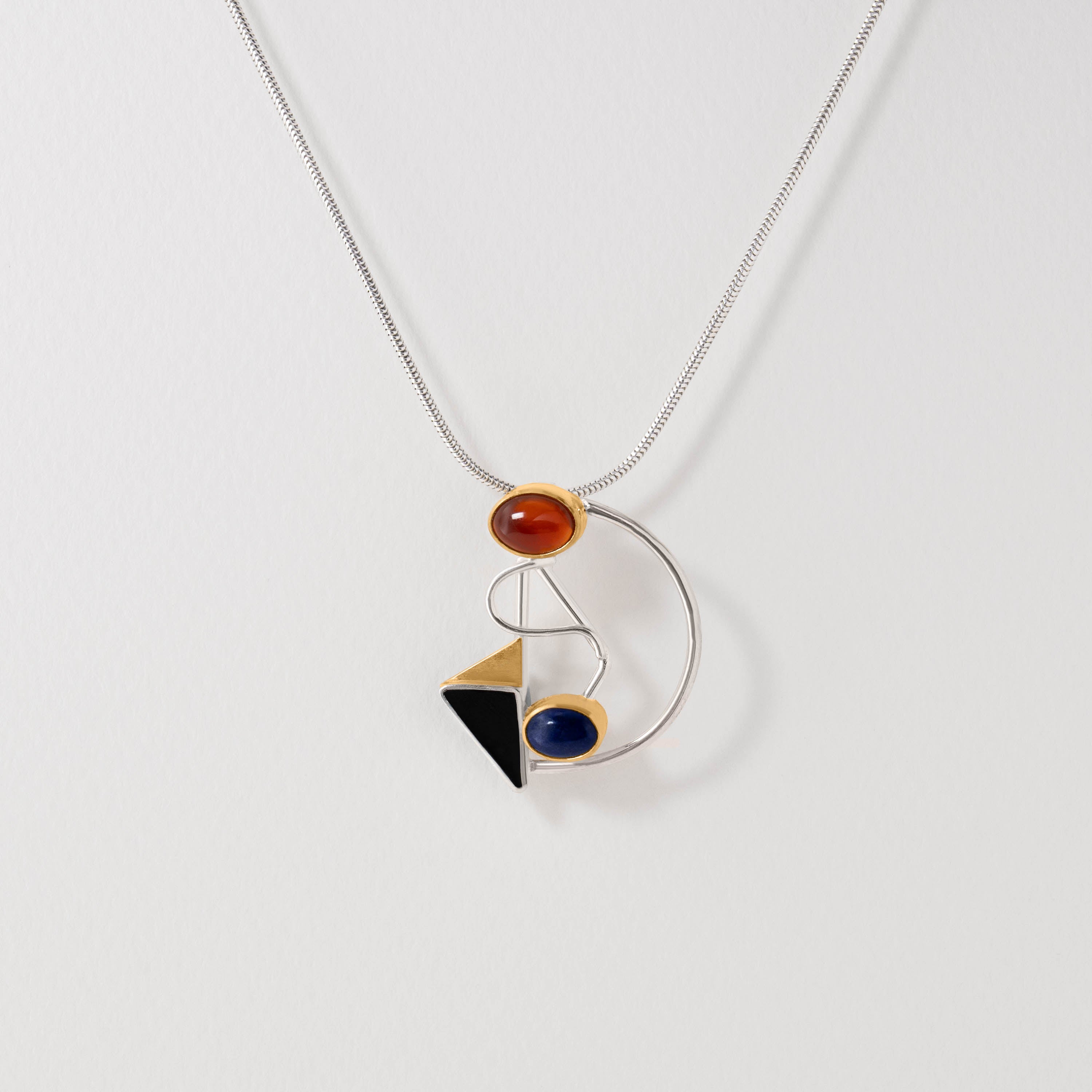 Abstract Kandinsky pendant necklace crafted in sterling silver with gold-plated detail. Featuring dynamic geometric forms set with carnelian, lapis lazuli and onyx, the design reflects the artist’s avant-garde style and vivid use of colour.