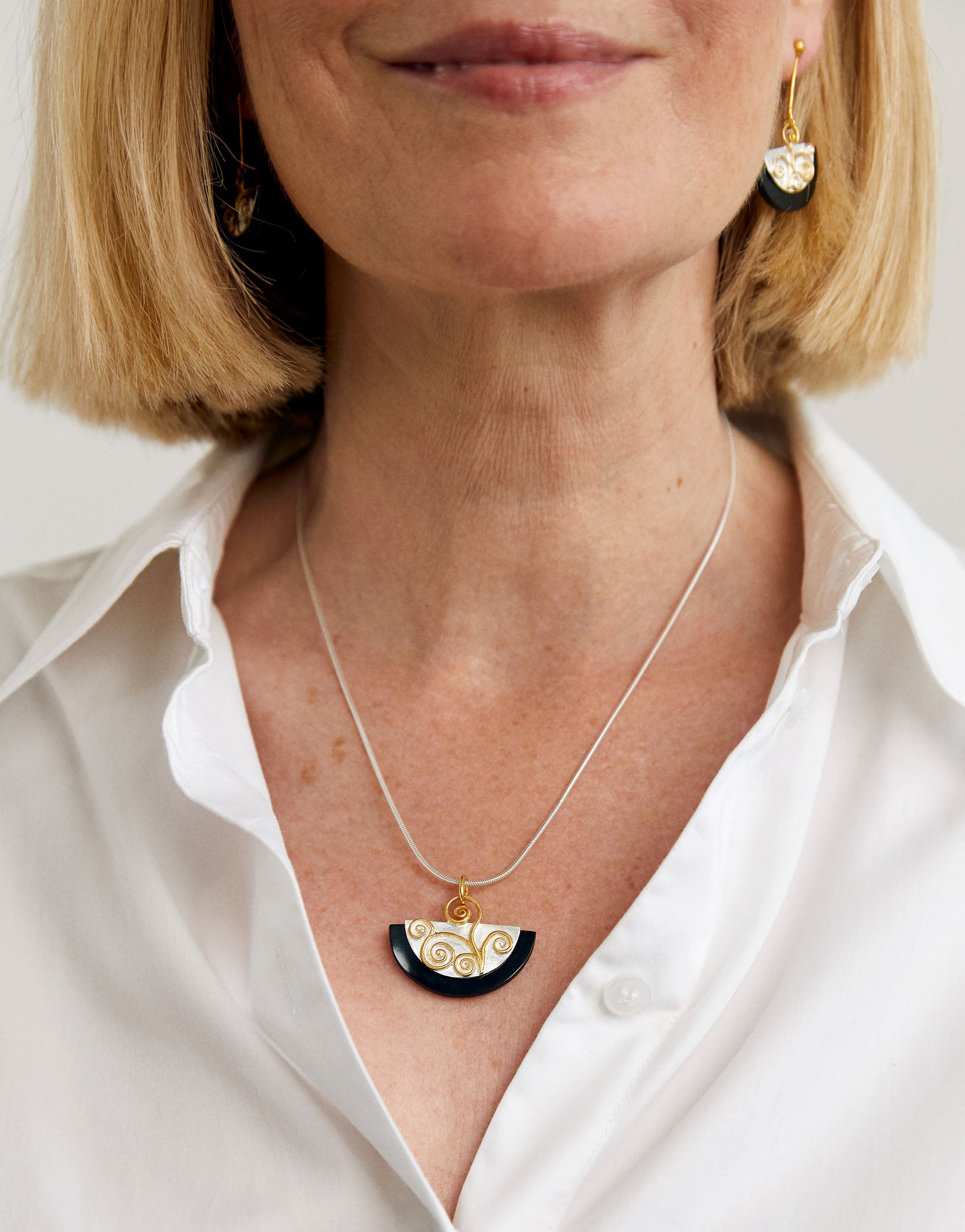 Art-inspired Klimt pendant necklace in silver with gold and black resin accents.