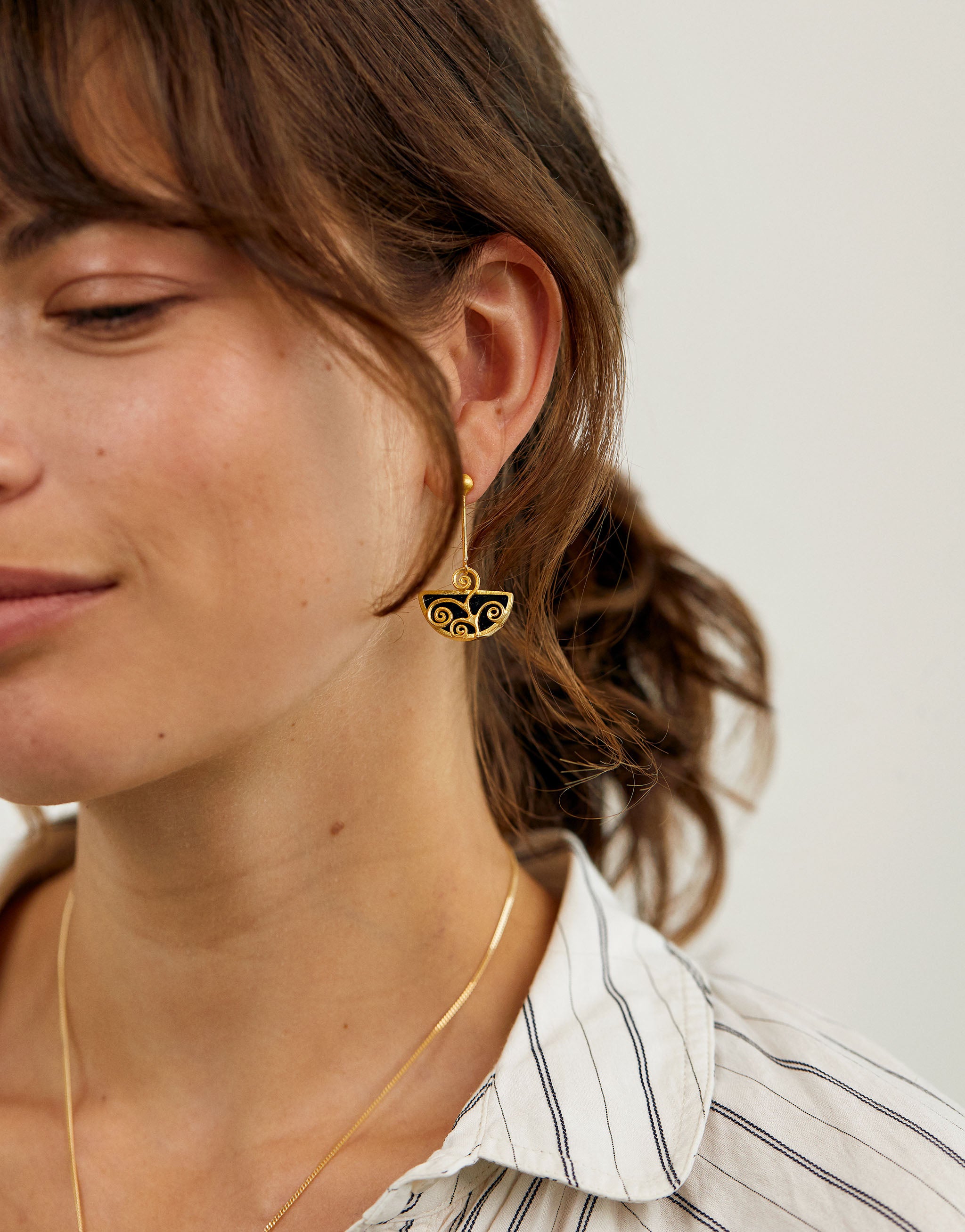 Gustav Klimt style earrings featuring swirling gold designs with black resin.