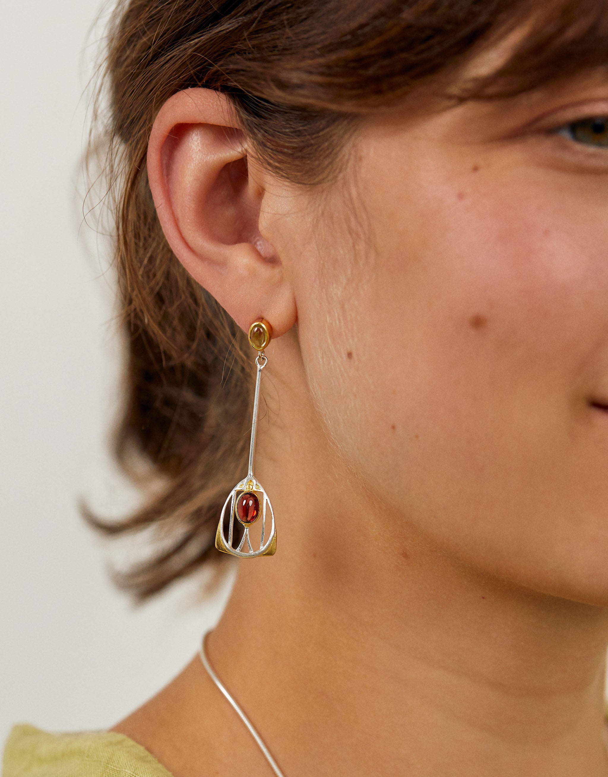 Art Nouveau style Macdonald drop earrings with silver, gold accents, garnet and peridot gemstones.