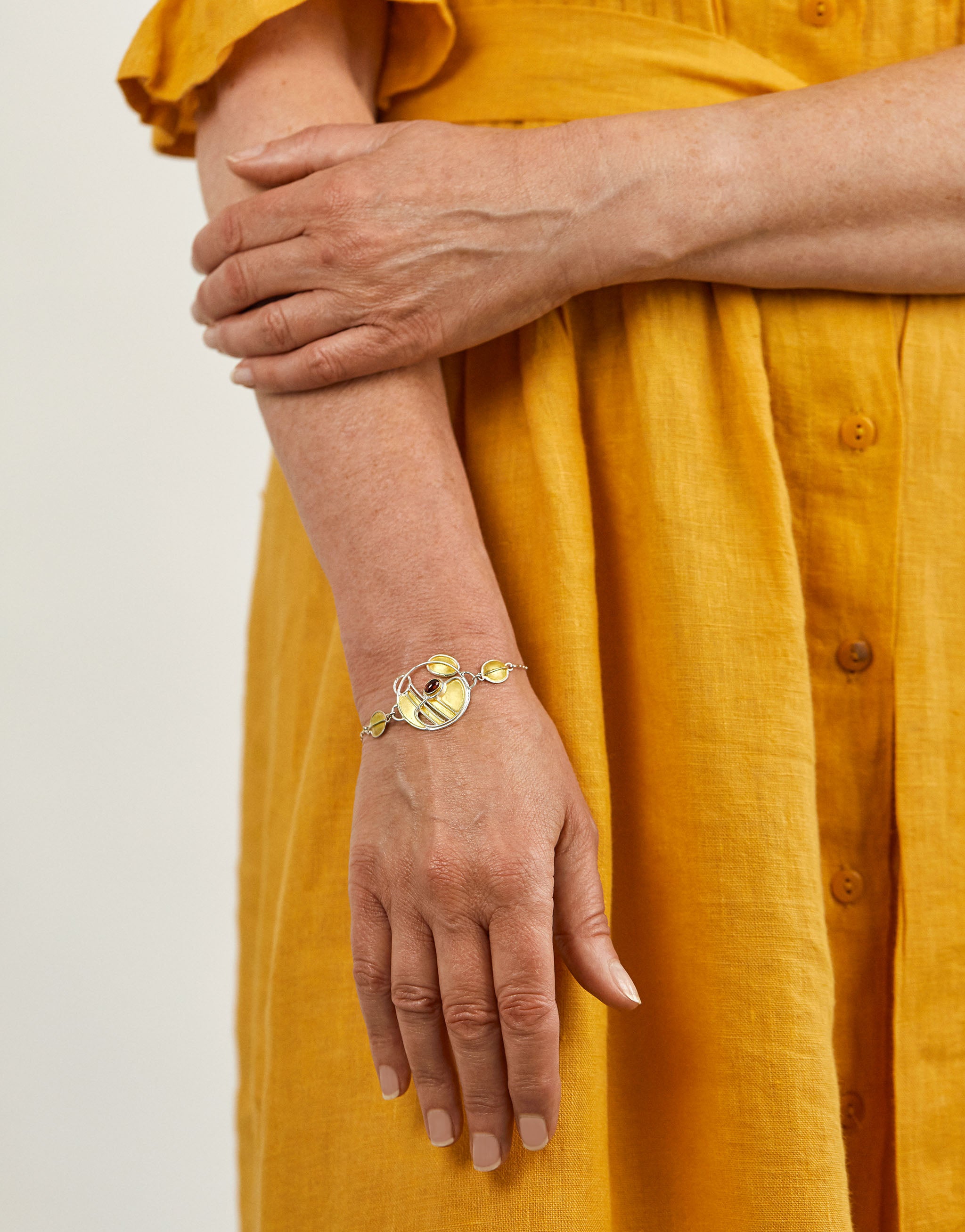 Charles Rennie Mackintosh inspired bracelet in sterling silver with 18ct gold plate and garnet gemstone.