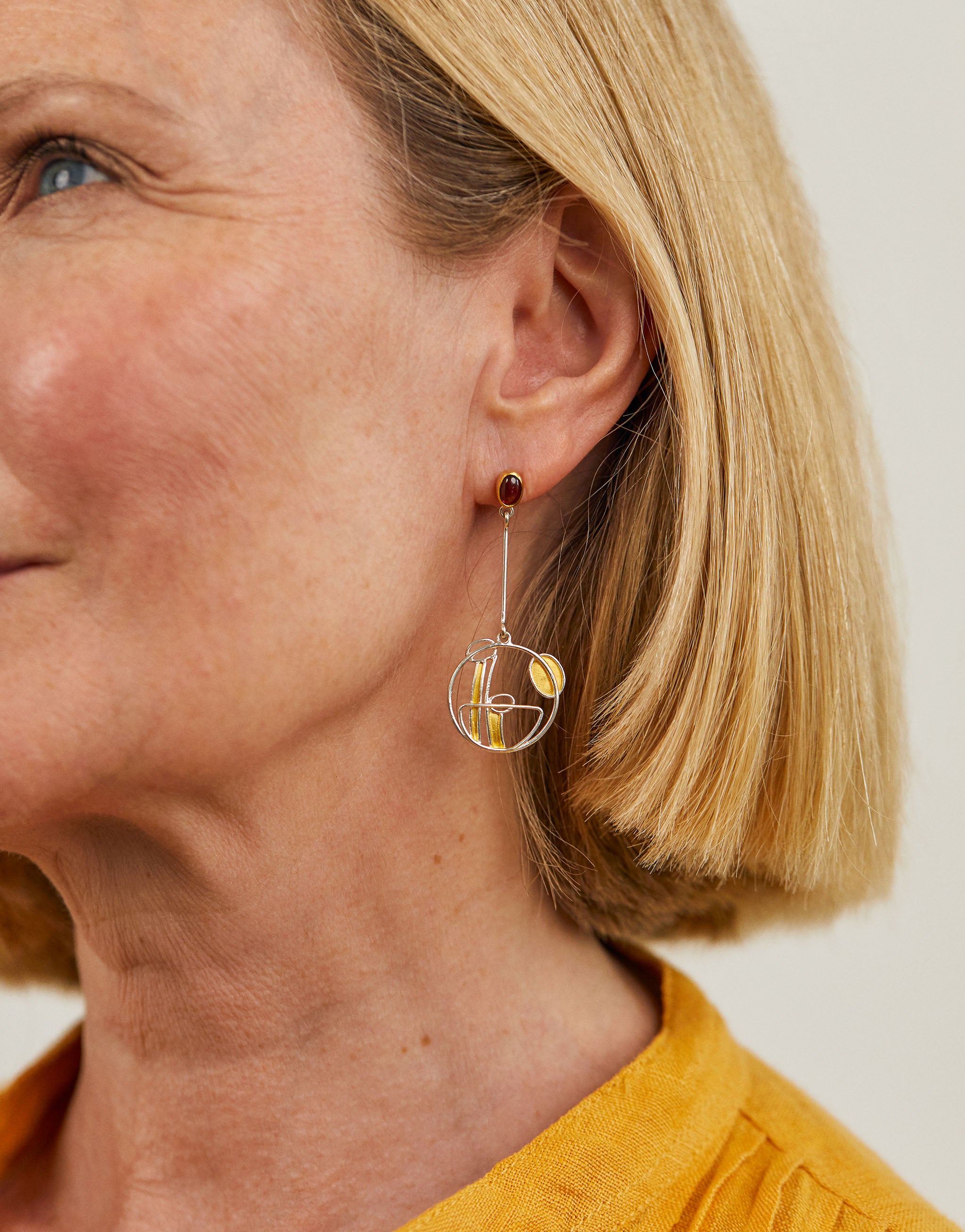Art Nouveau style Mackintosh earrings with silver, gold accents and garnet gemstone.