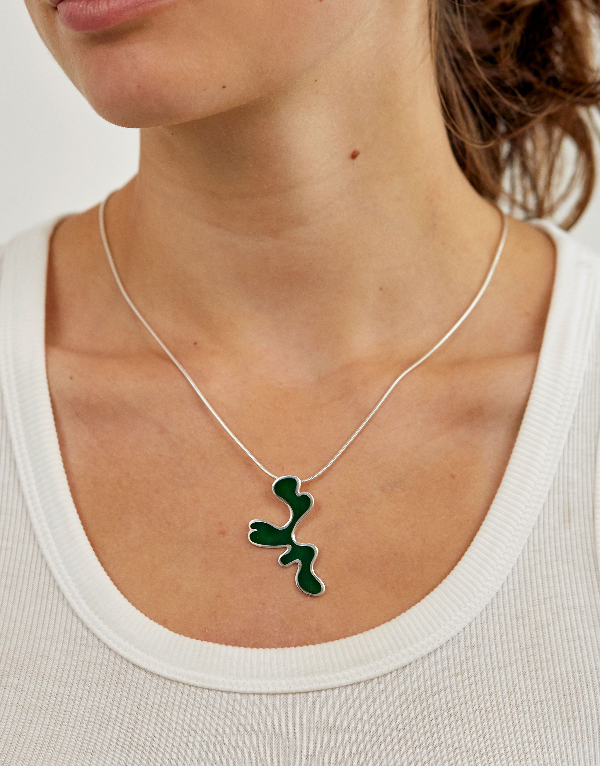 Henri Matisse style pendant necklace with silver design and green resin detail.