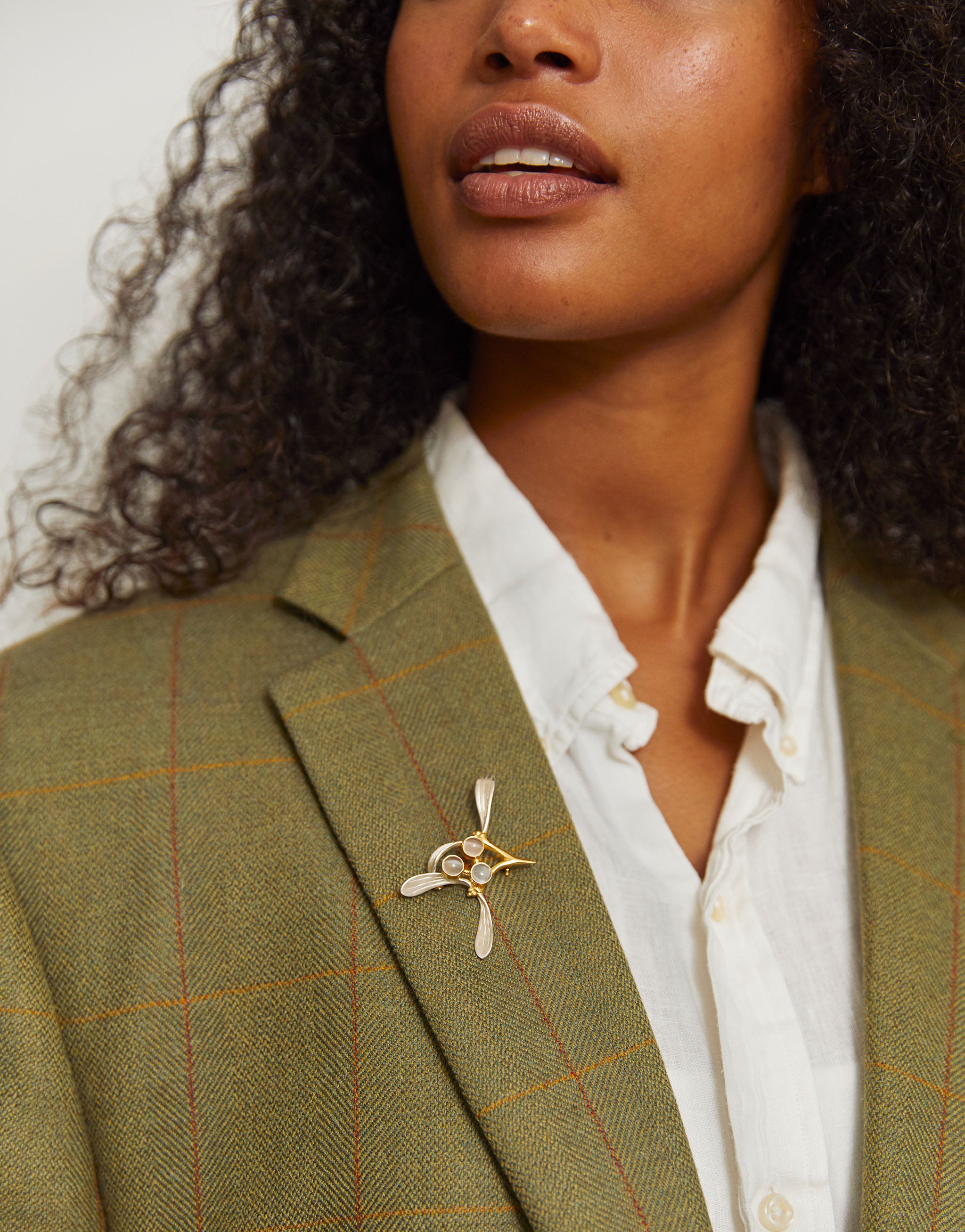 Festive mistletoe brooch with silver, gold detailing and luminous moonstones.