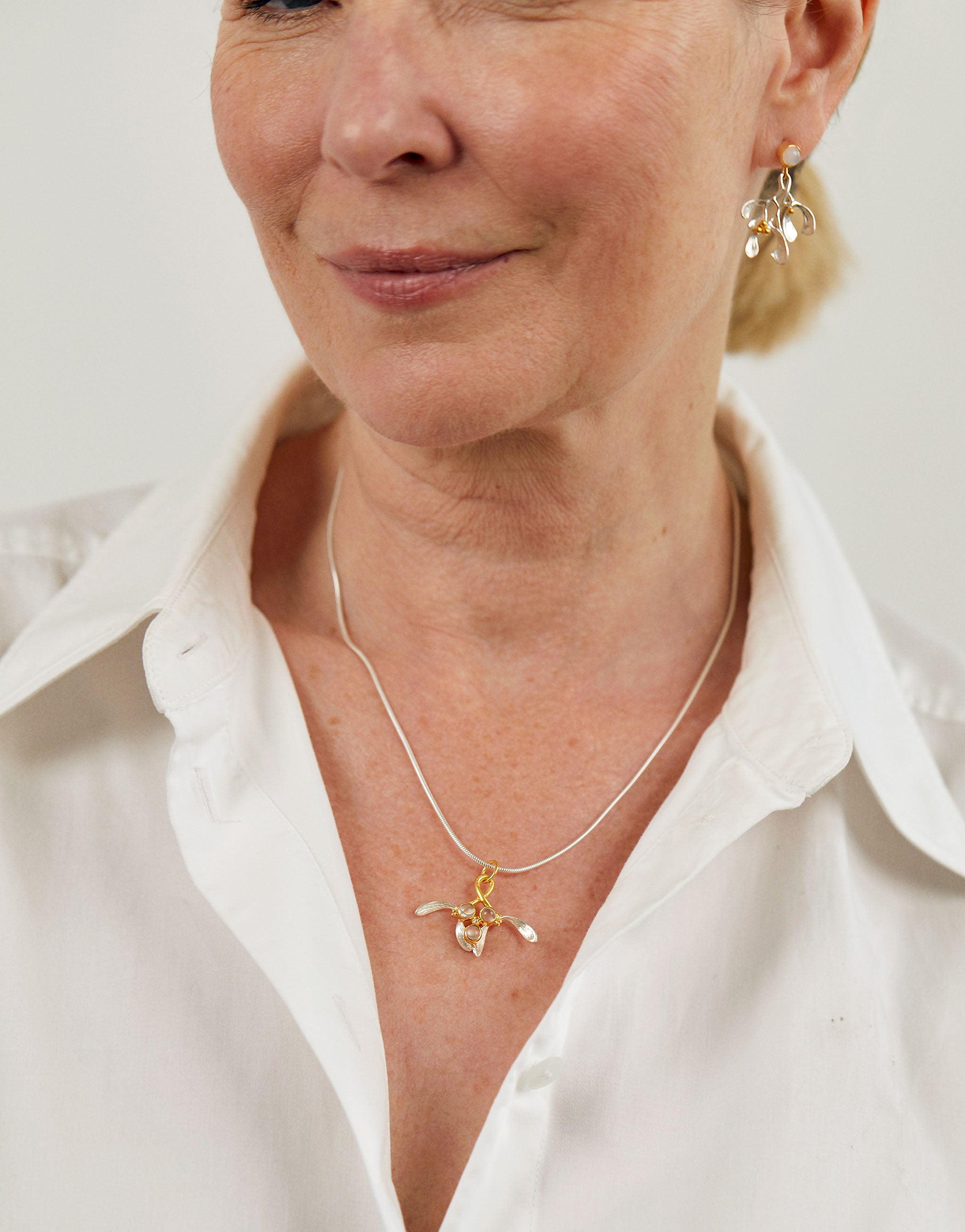 Christmas inspired mistletoe necklace in silver with gold-plated detail and moonstone gemstones.
