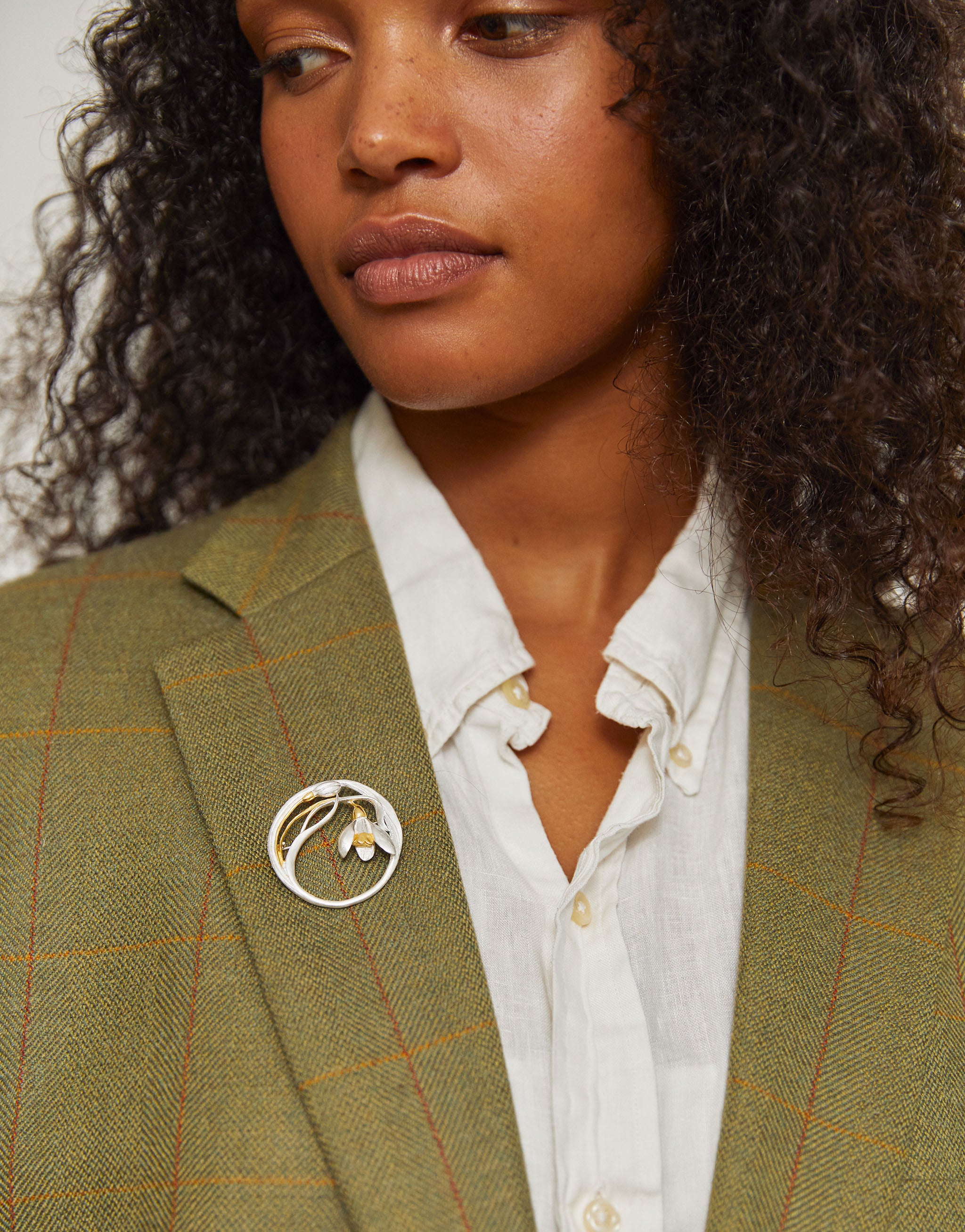 Floral snowdrop brooch in silver and gold, symbolising spring and renewal.