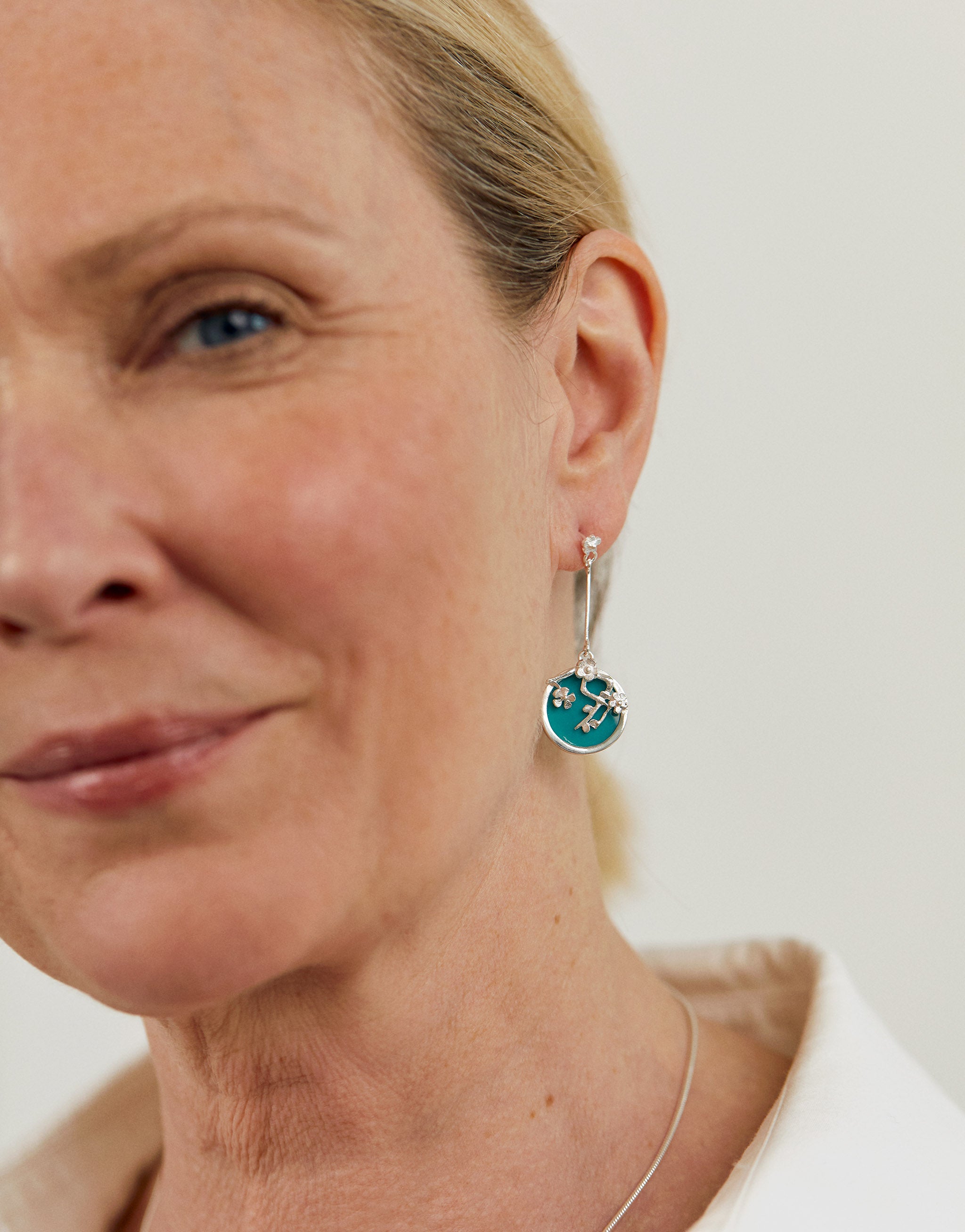 Art-inspired earrings with silver blossom design and blue resin, inspired by Van Gogh.