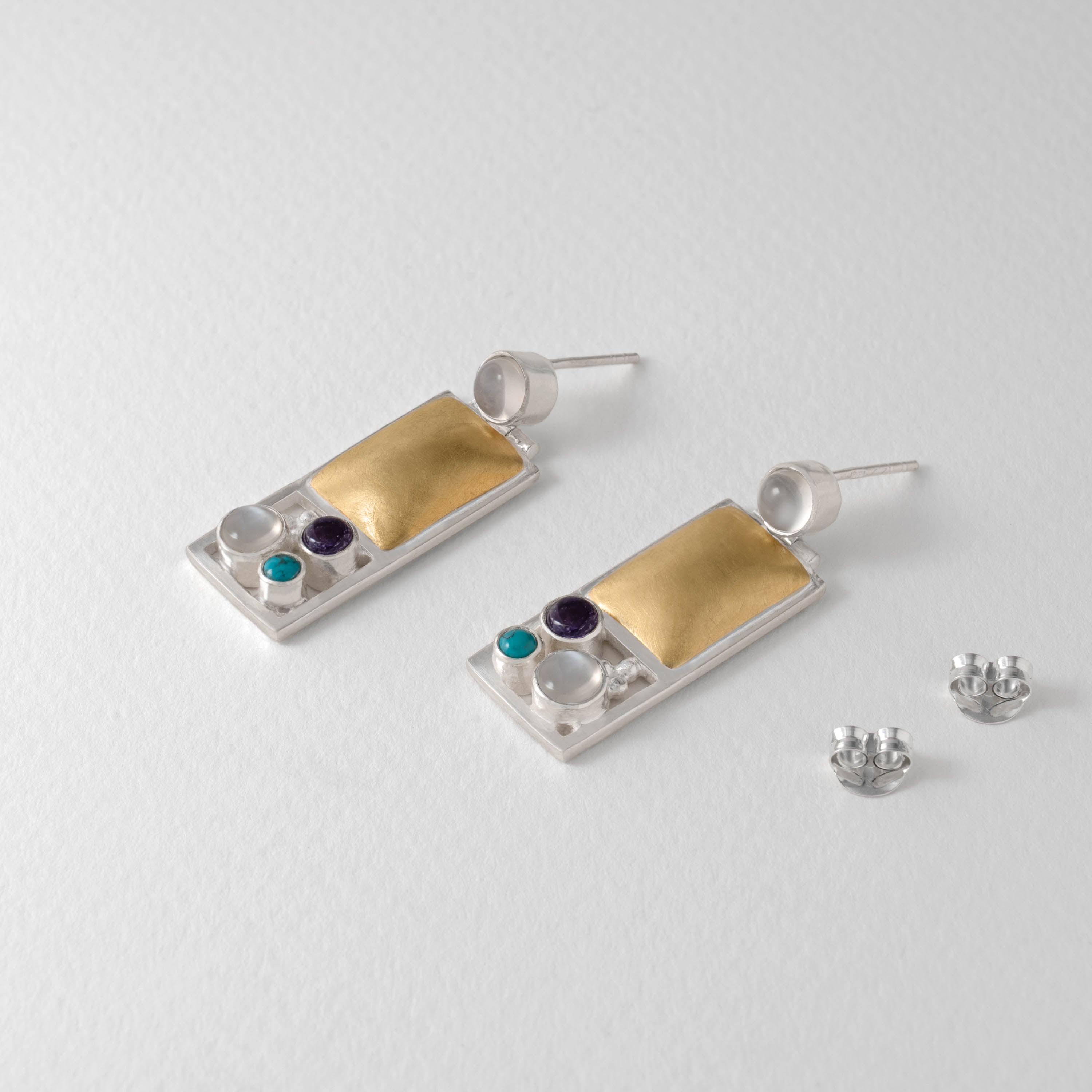 Sterling silver Hoffmann Vienna earrings with gold-plated panels and gemstone accents. Set with moonstone, iolite and turquoise, the geometric design echoes Hoffmann’s refined Viennese modernist style.