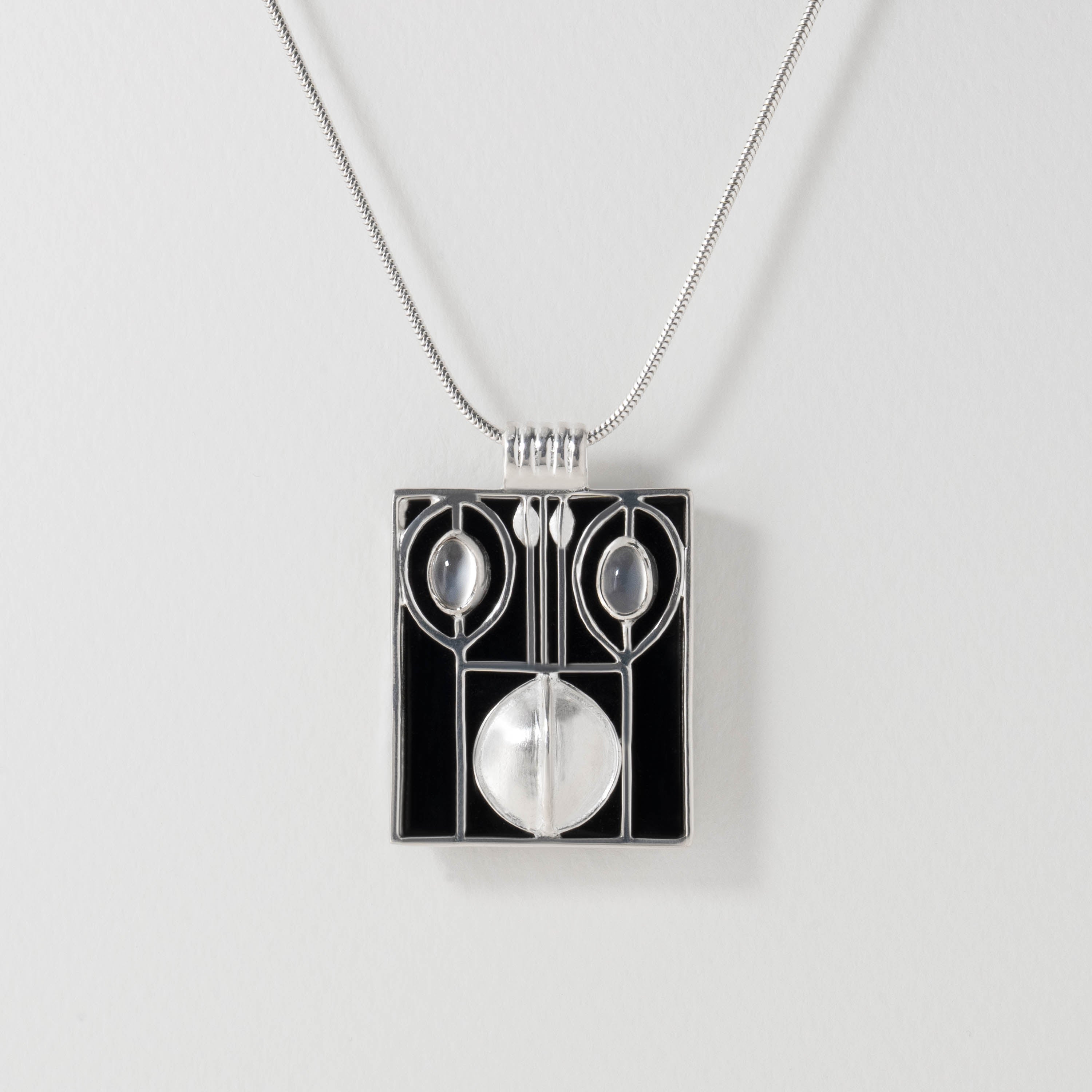 Wiener Werkstätte inspired pendant necklace in sterling silver with black resin. The bold geometric design reflects early modernist style, balancing clean lines with structured elegance, finished with a luminous moonstone accent.