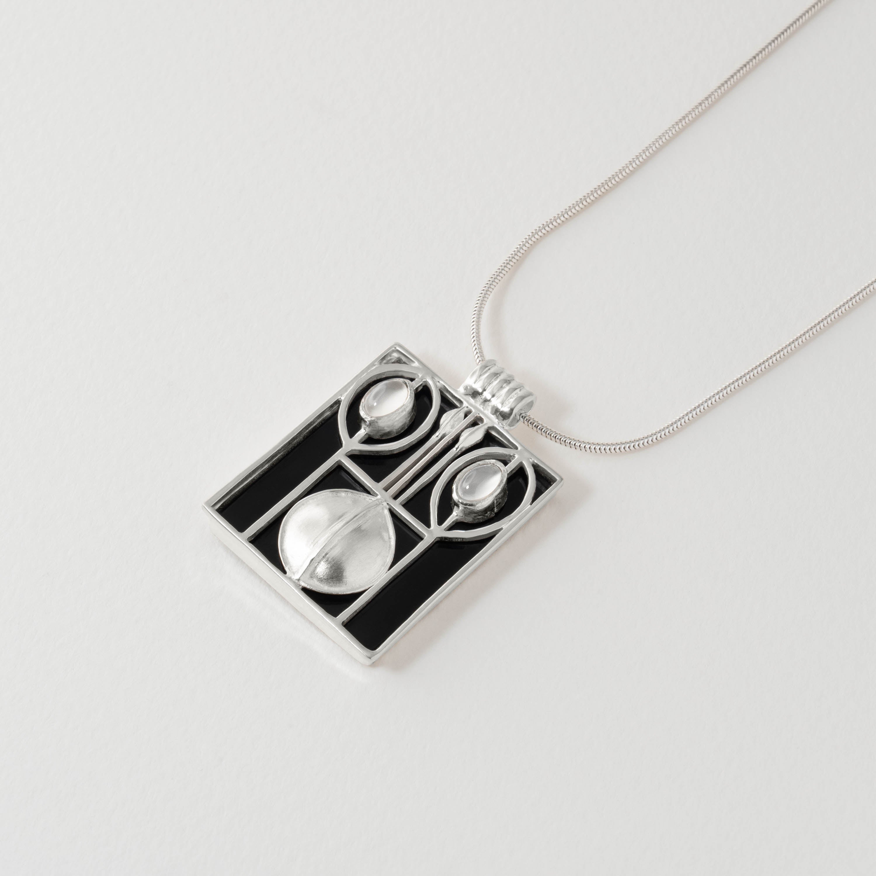 Geometric pendant necklace inspired by the Wiener Werkstätte, handcrafted in sterling silver with black resin. Showcasing the movement’s modernist elegance, the design contrasts bold structure with the soft glow of a moonstone detail.