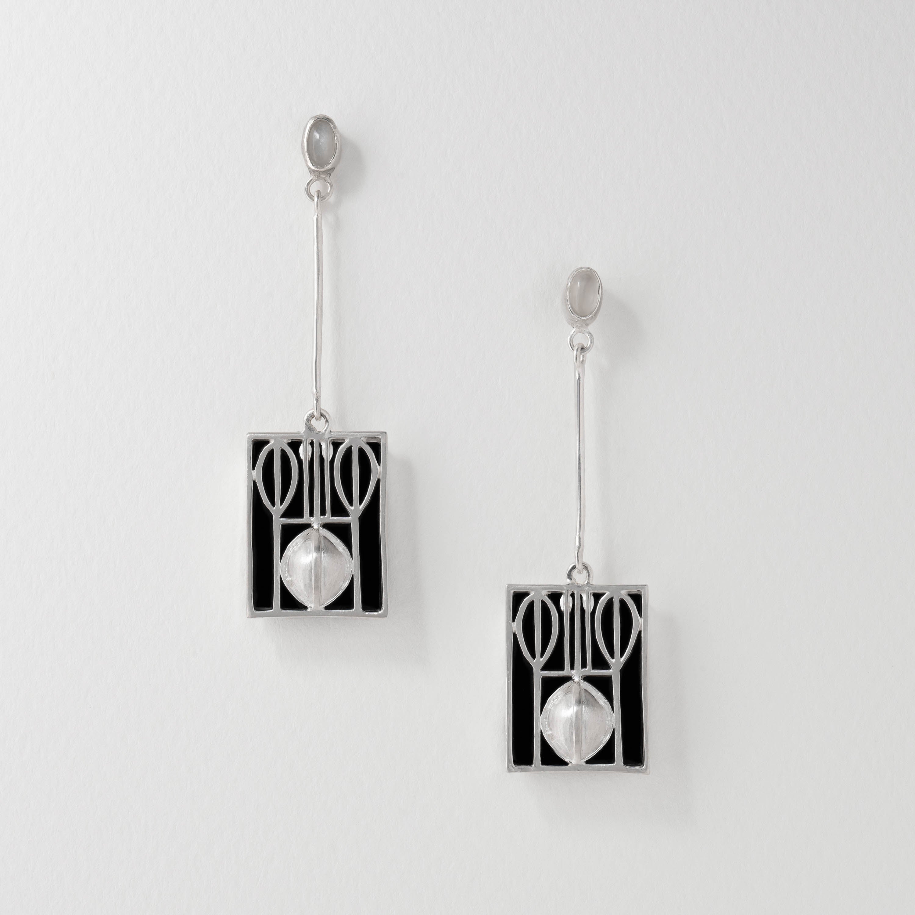 Wiener Werkstätte inspired drop earrings in sterling silver with black resin and moonstone. The geometric Art Nouveau design features clean lines and abstract shapes, reflecting early modernist craftsmanship and elegance.