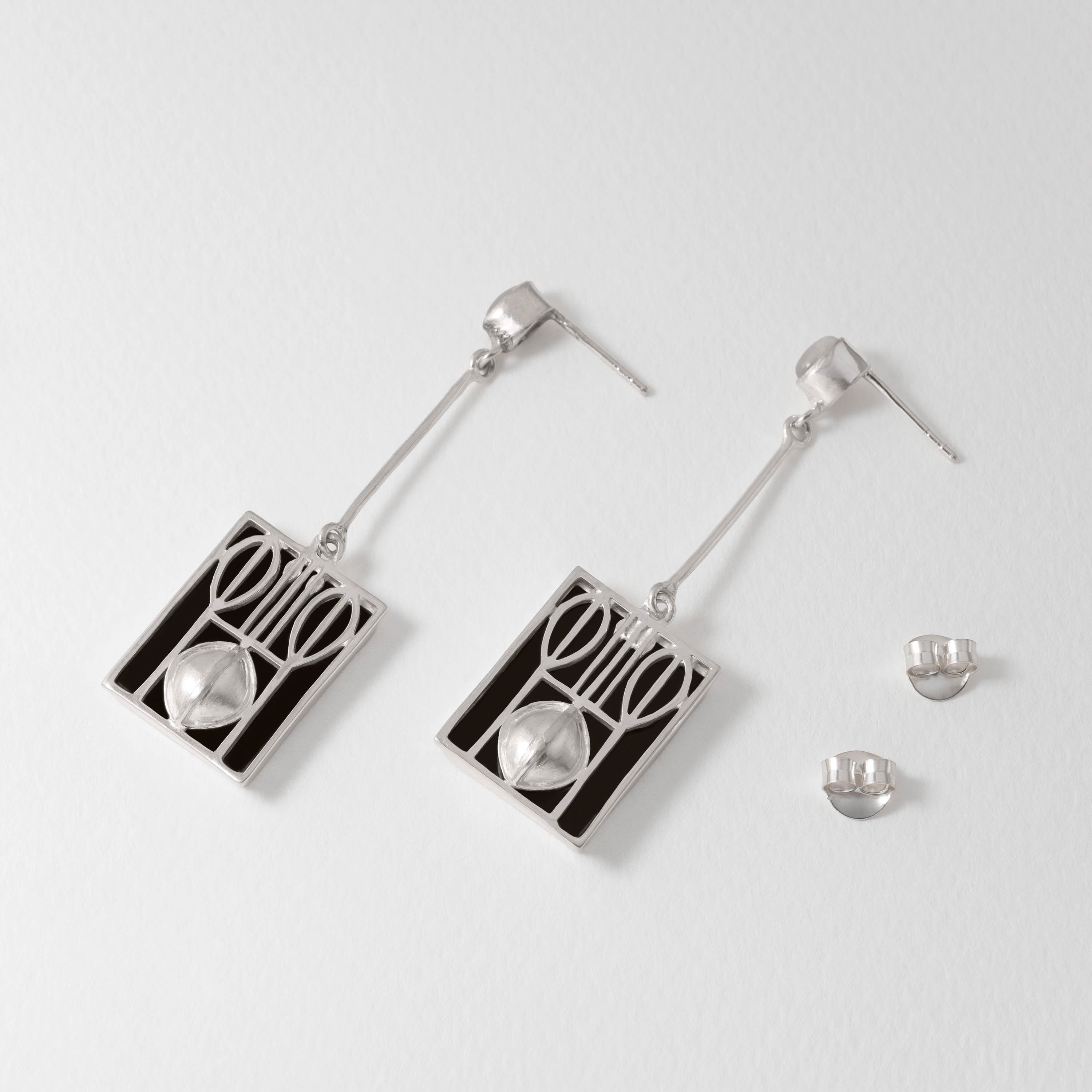Geometric Wiener Werkstätte drop earrings handcrafted in sterling silver with black resin panels and luminous moonstone. A striking modernist design that blends bold abstraction with refined elegance.