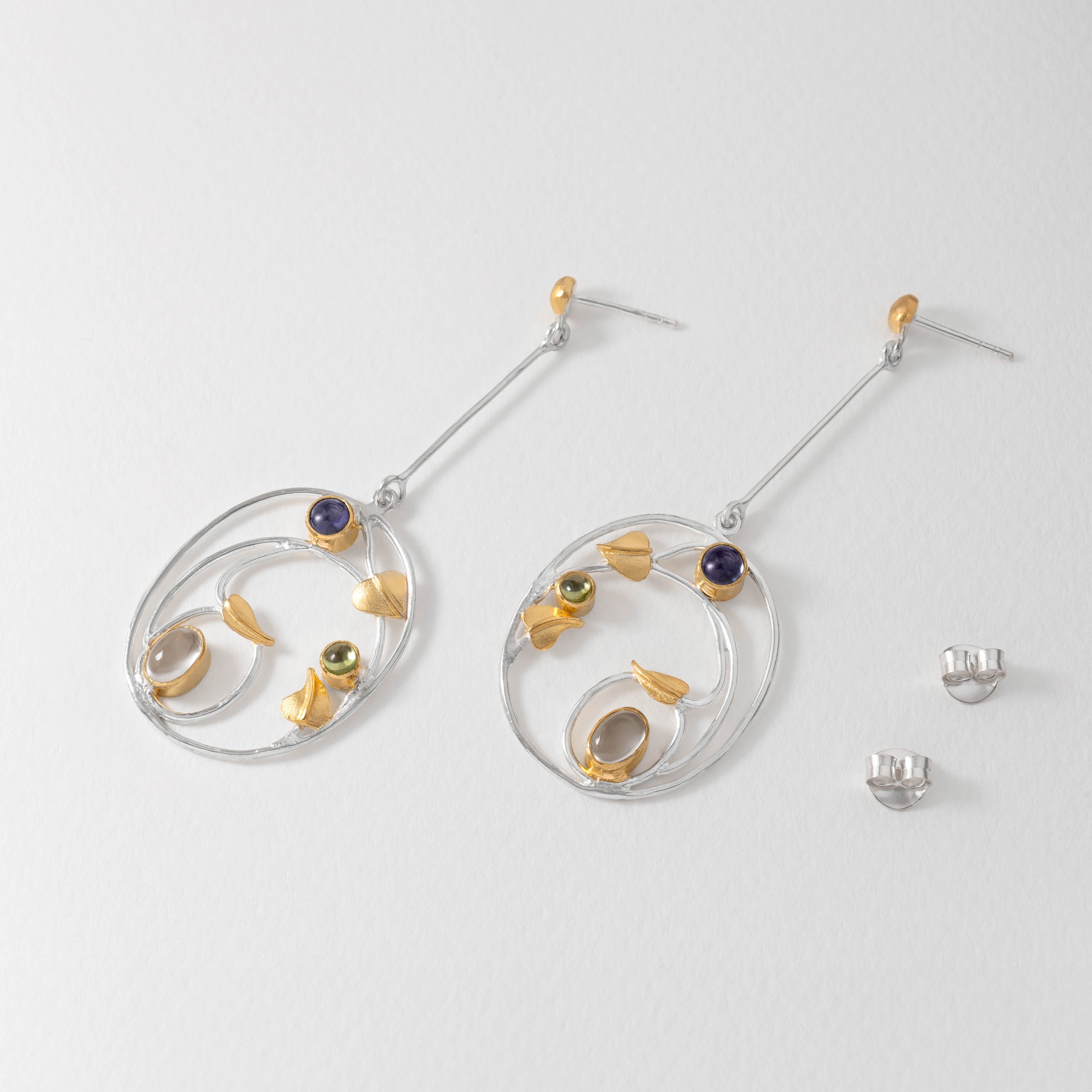 Margaret Macdonald inspired Willowwood drop earrings in sterling silver with iolite and peridot gemstones. Art Nouveau design echoing her Gesso panels and Willow Tea Rooms motifs.