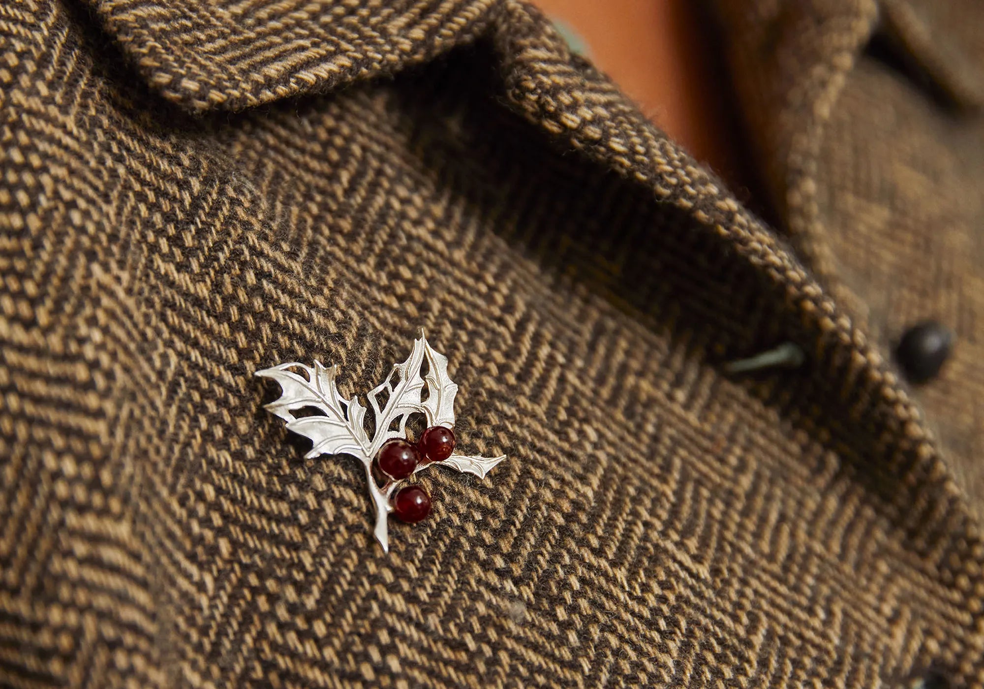 Festive holly brooch with red cabochon garnet berries made from garnet.