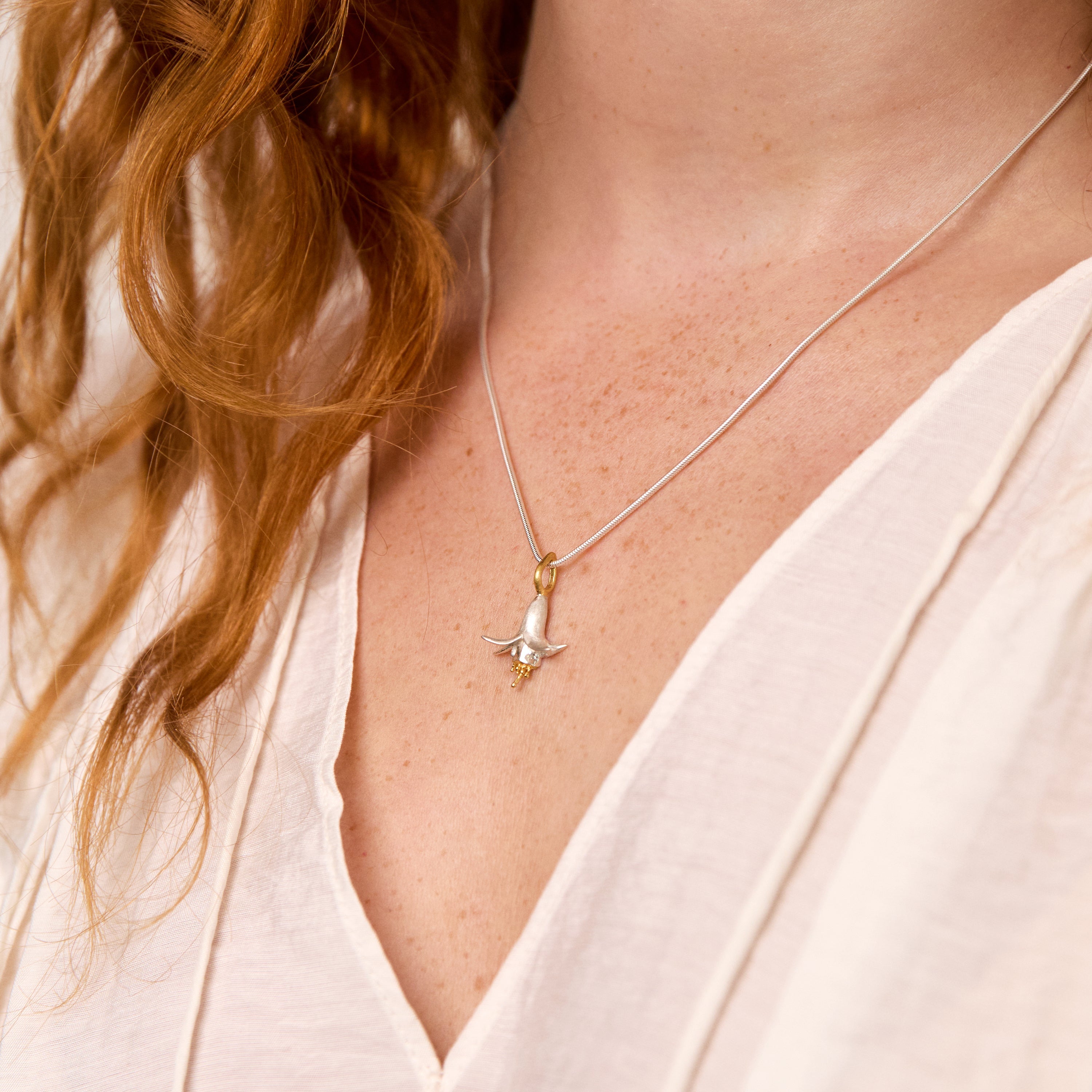 Flower necklace pendants in silver and gold.