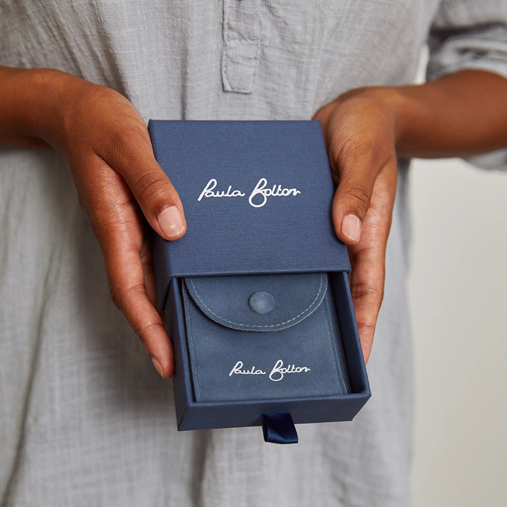 A blue jewellery box with 'Paula Bolton' branding.