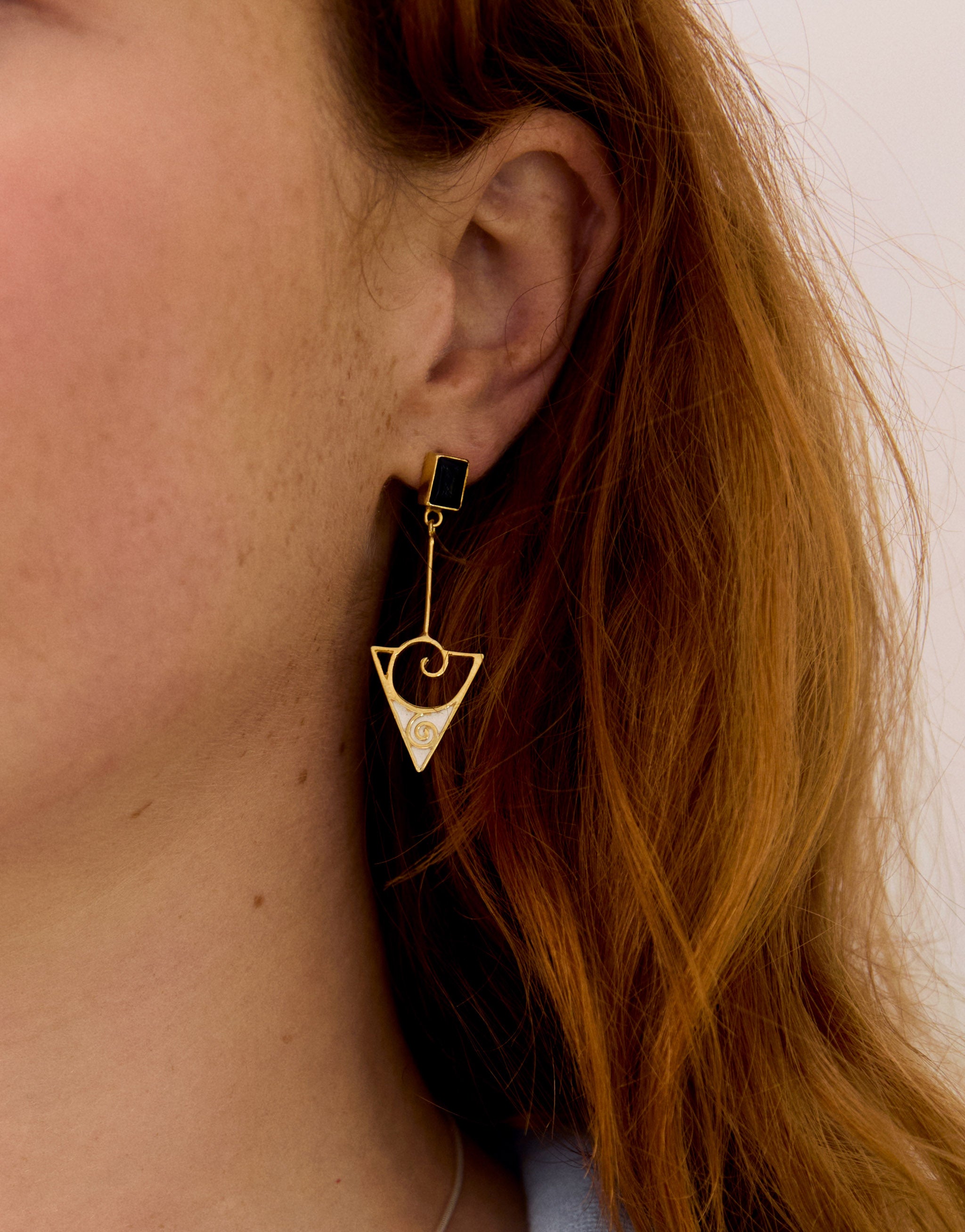 Gold triangular drop earrings with sterling silver, swirling design and black onyx gemstone