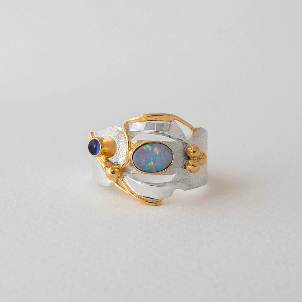 Silver and gold ring with a central opal gemstone