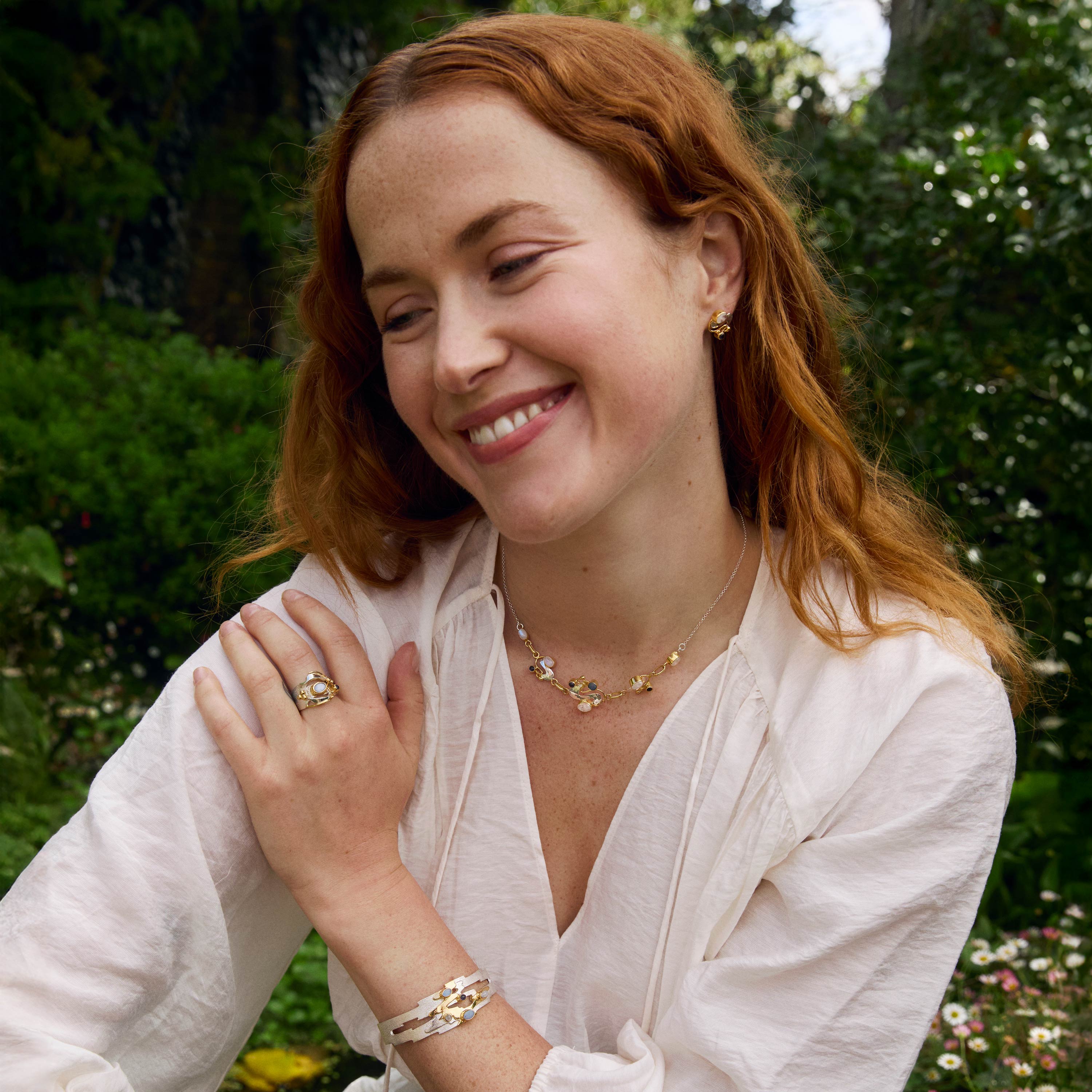 Red-haired woman wearing handcrafted silver jewellery inspired by the works of Claude Monet's waterlilies.