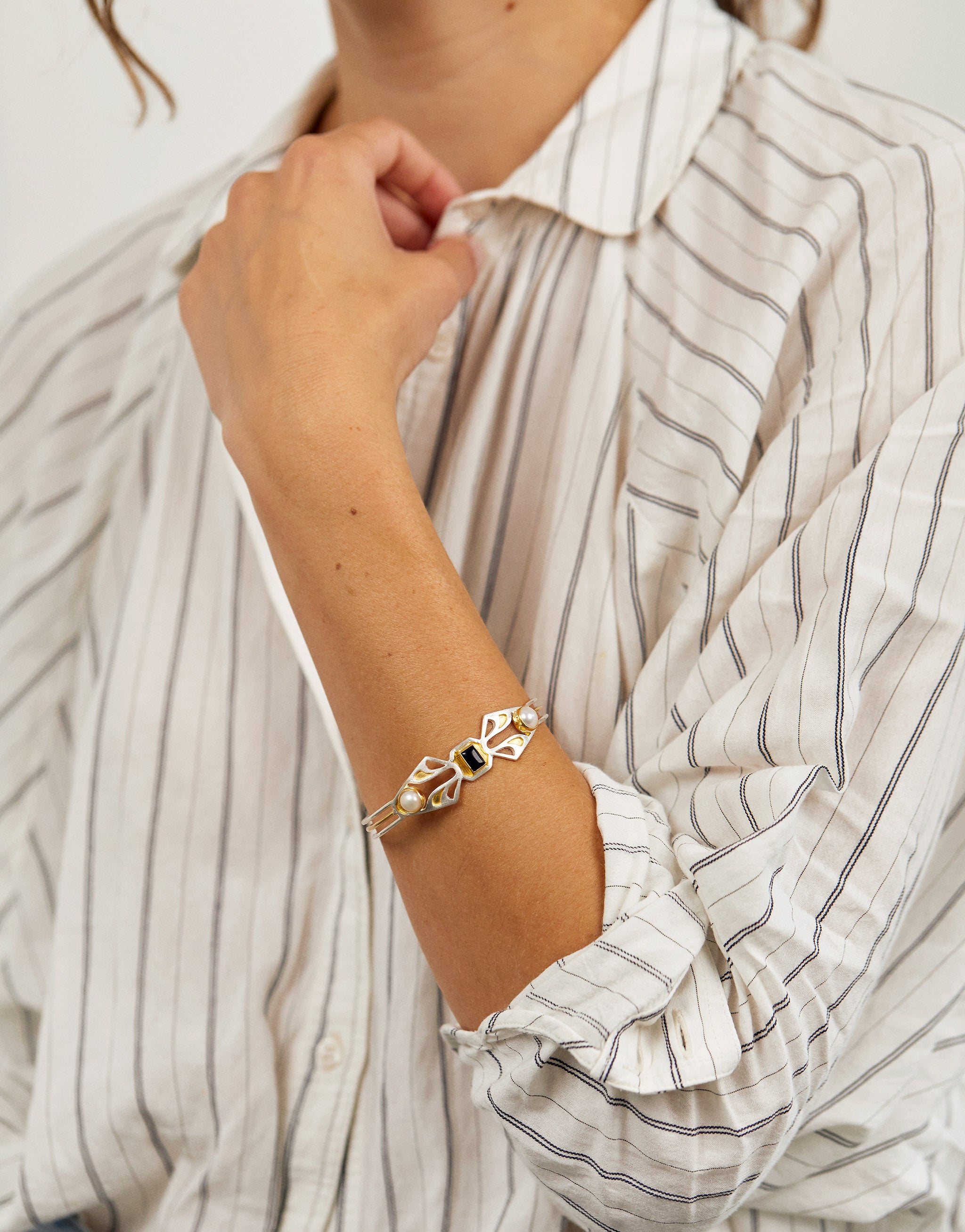 Handcrafted art deco bangle with sterling silver, 18ct gold pate, onyx and pearl. 